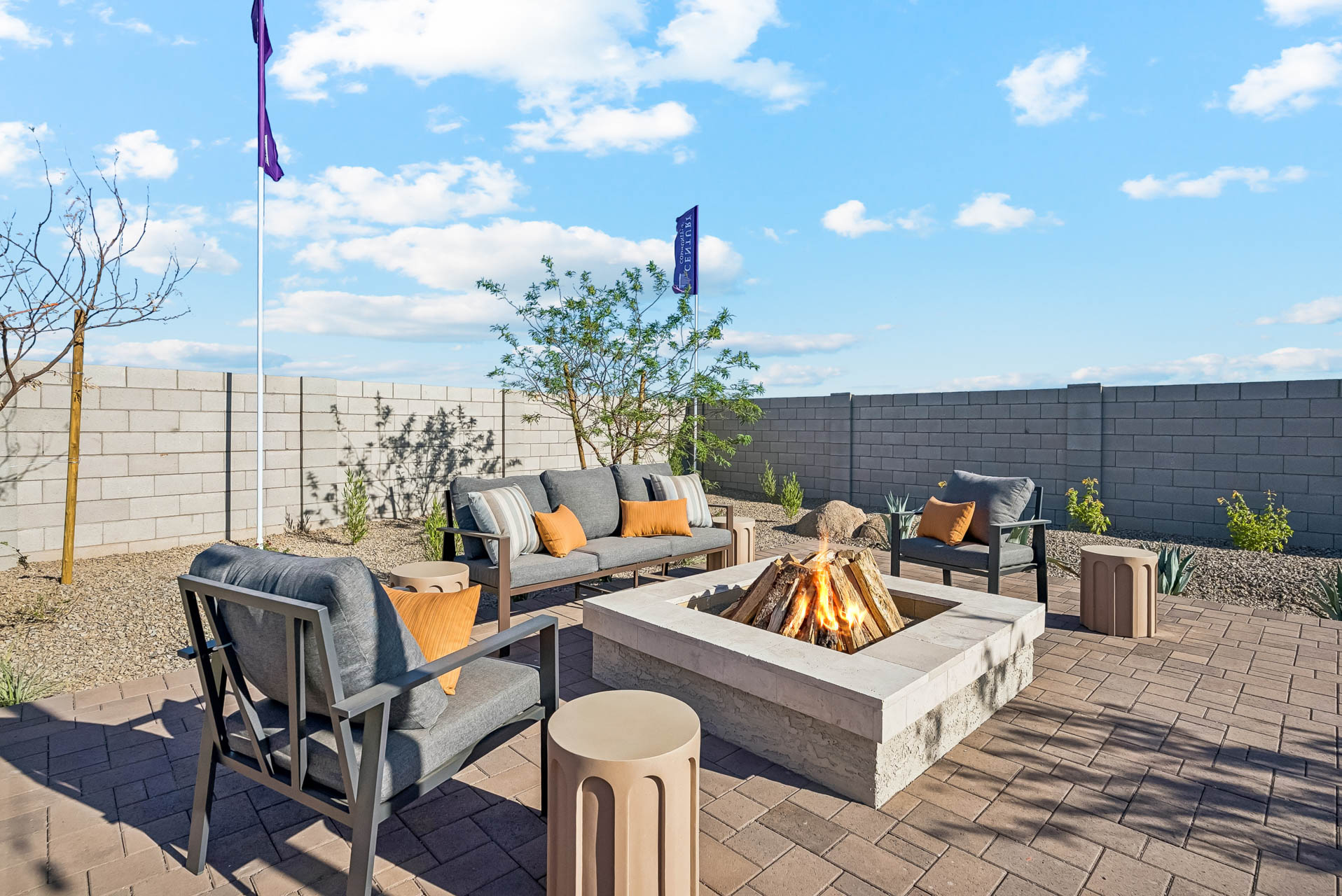 A patio with a fire pit and chairs and a fire pit.