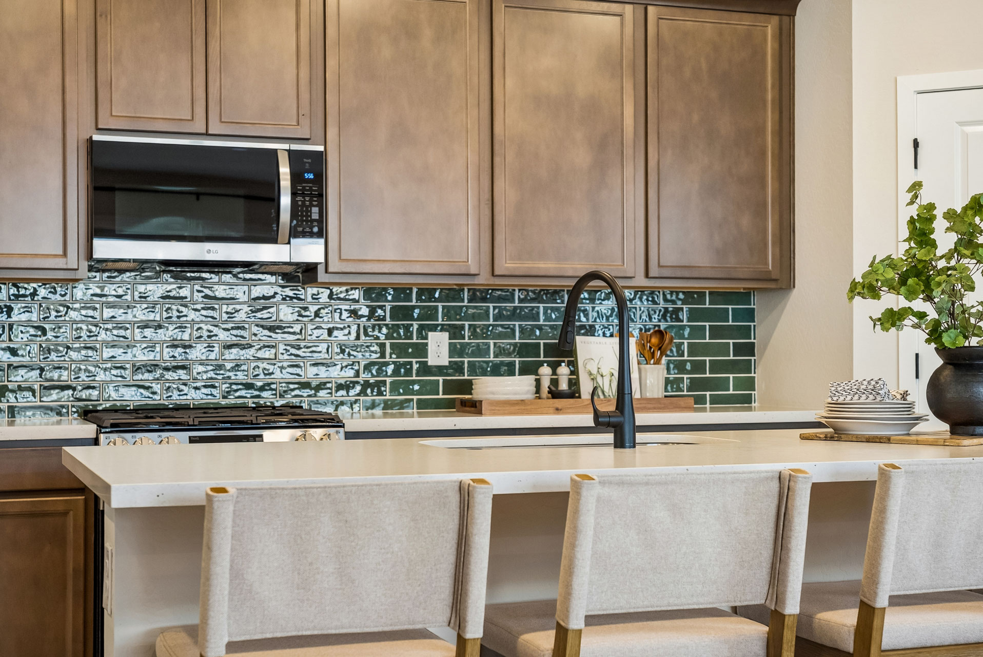 A kitchen with a microwave oven and chairs.
