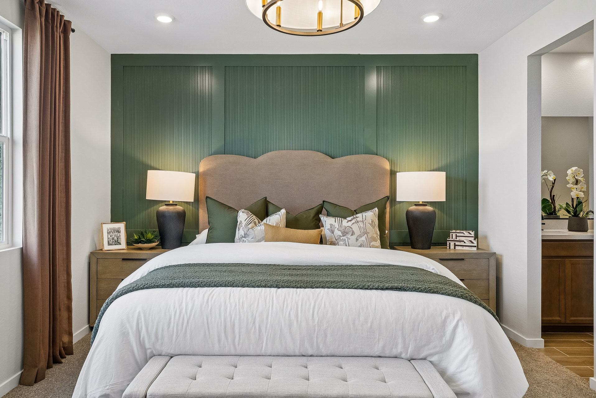 A bed with green curtains.