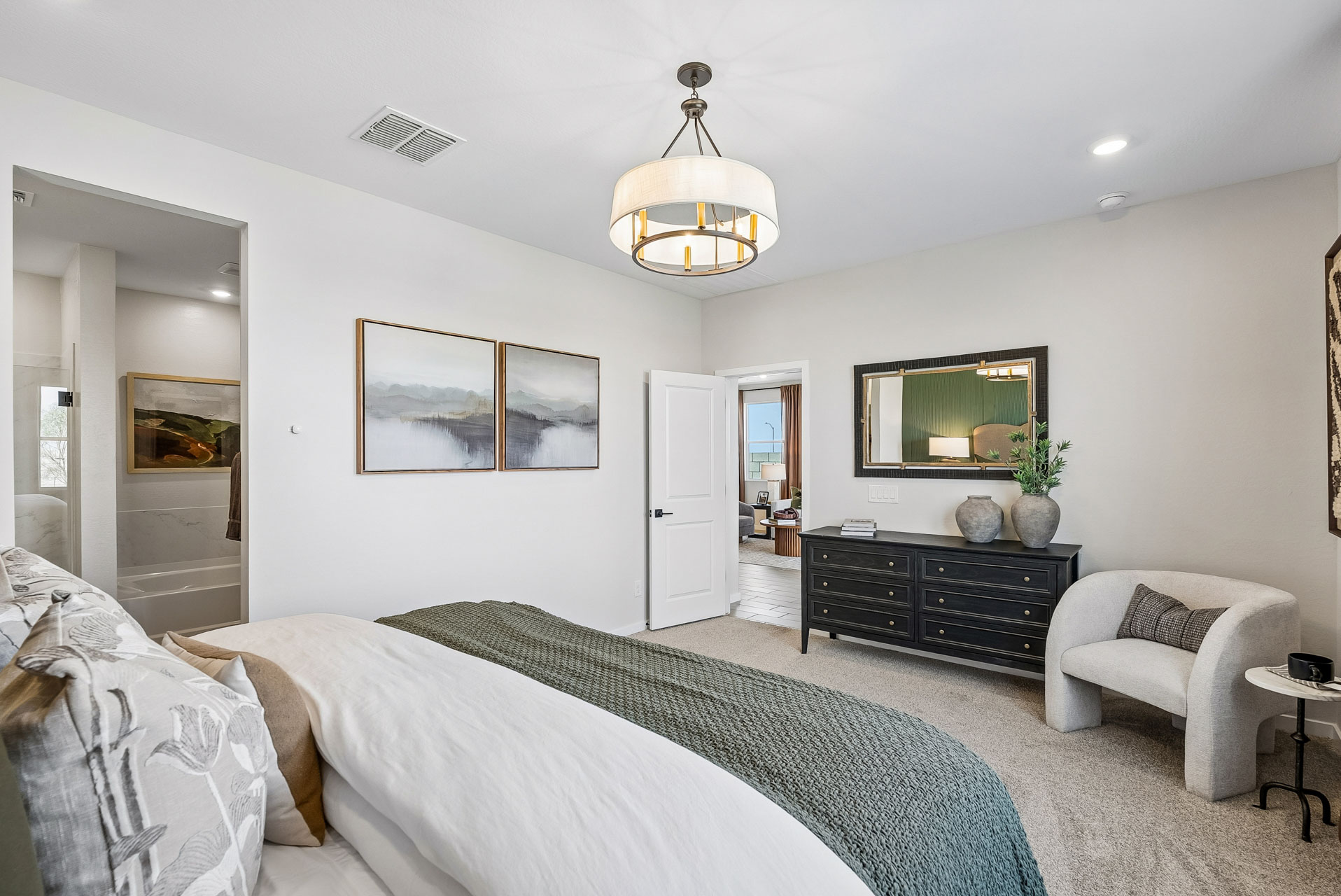 A bedroom with a bed and a chair.