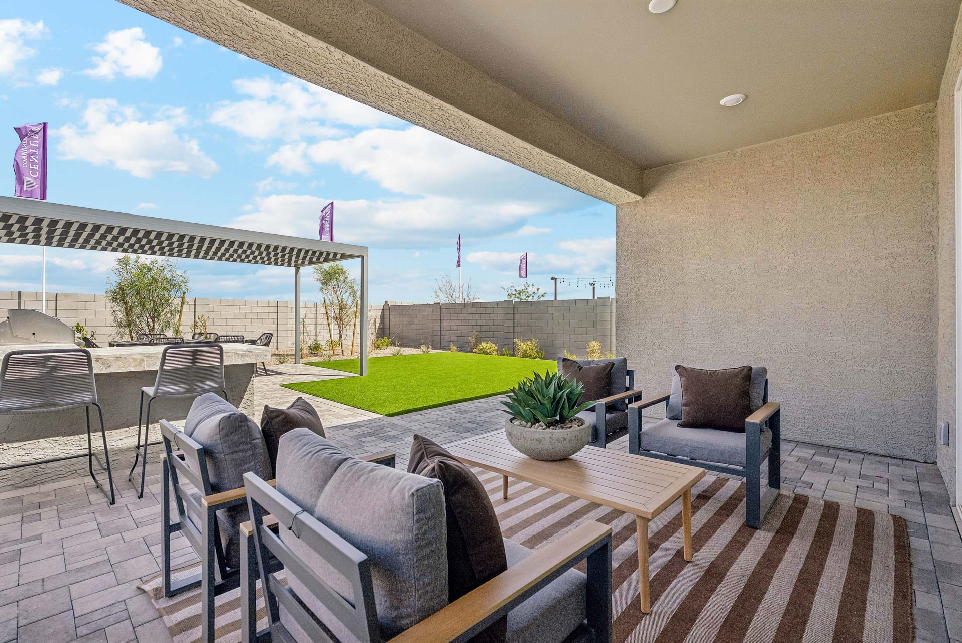 A patio with chairs and a table.