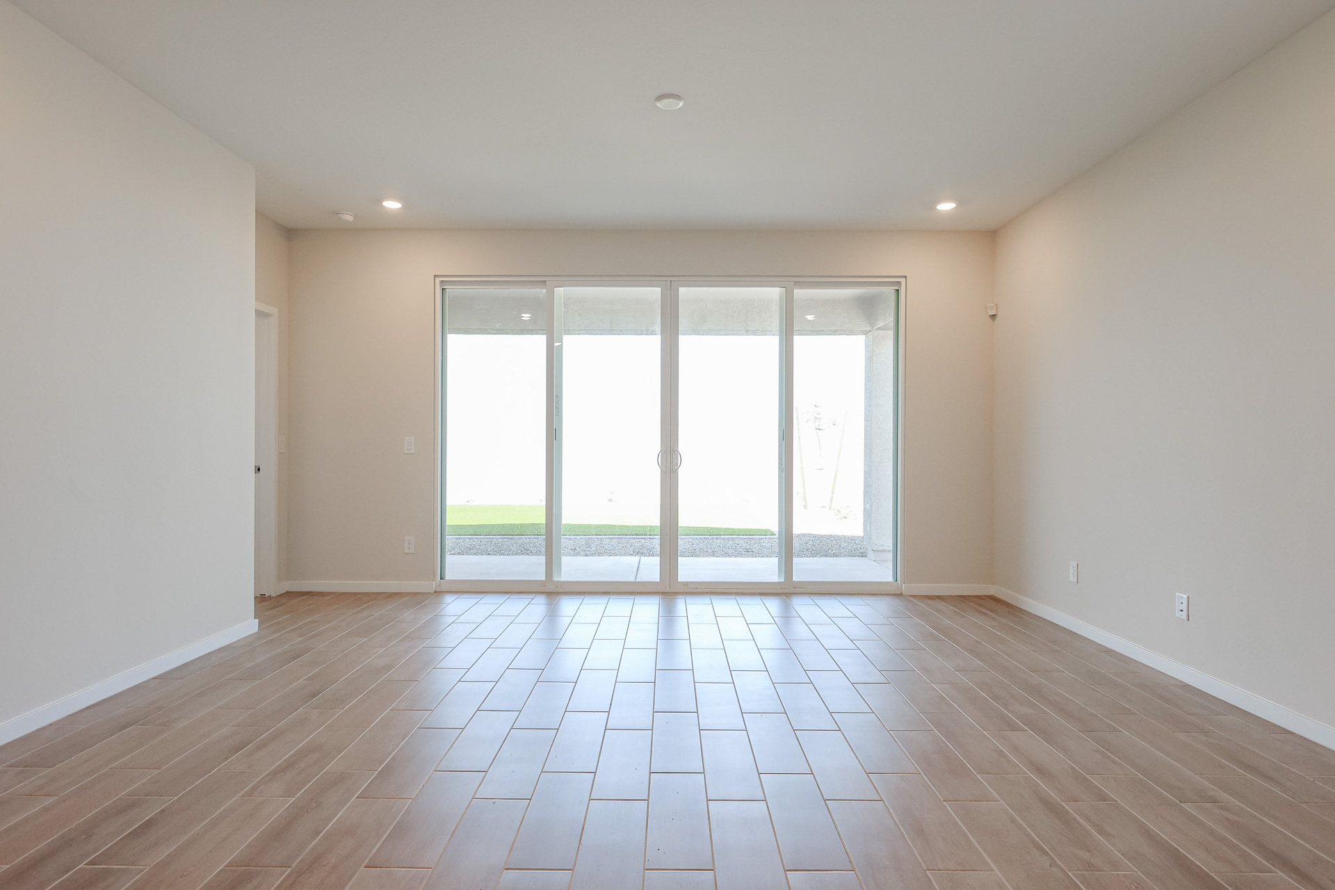A room with a wood floor and a large window.