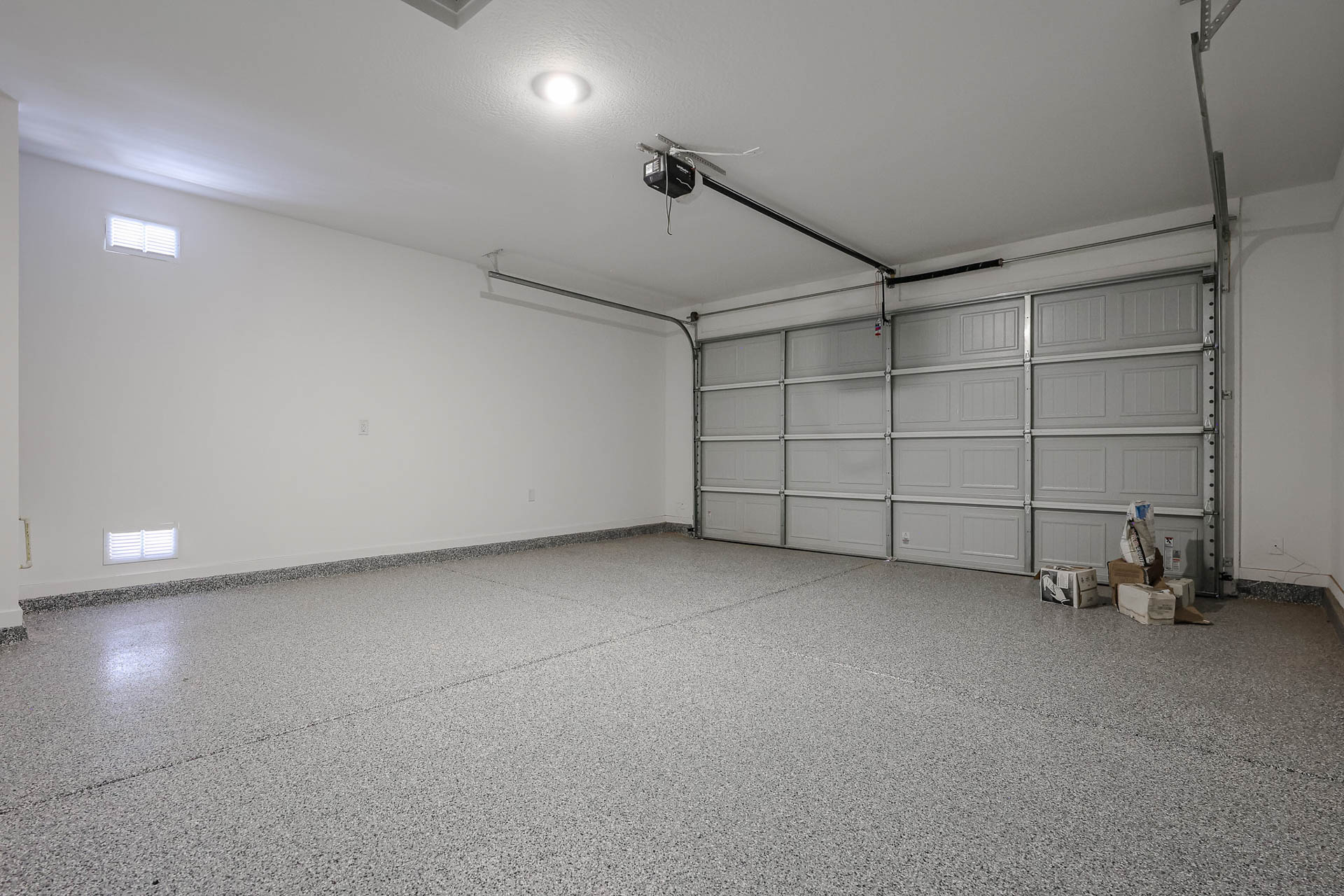 A room with a large white wall and a metal door.