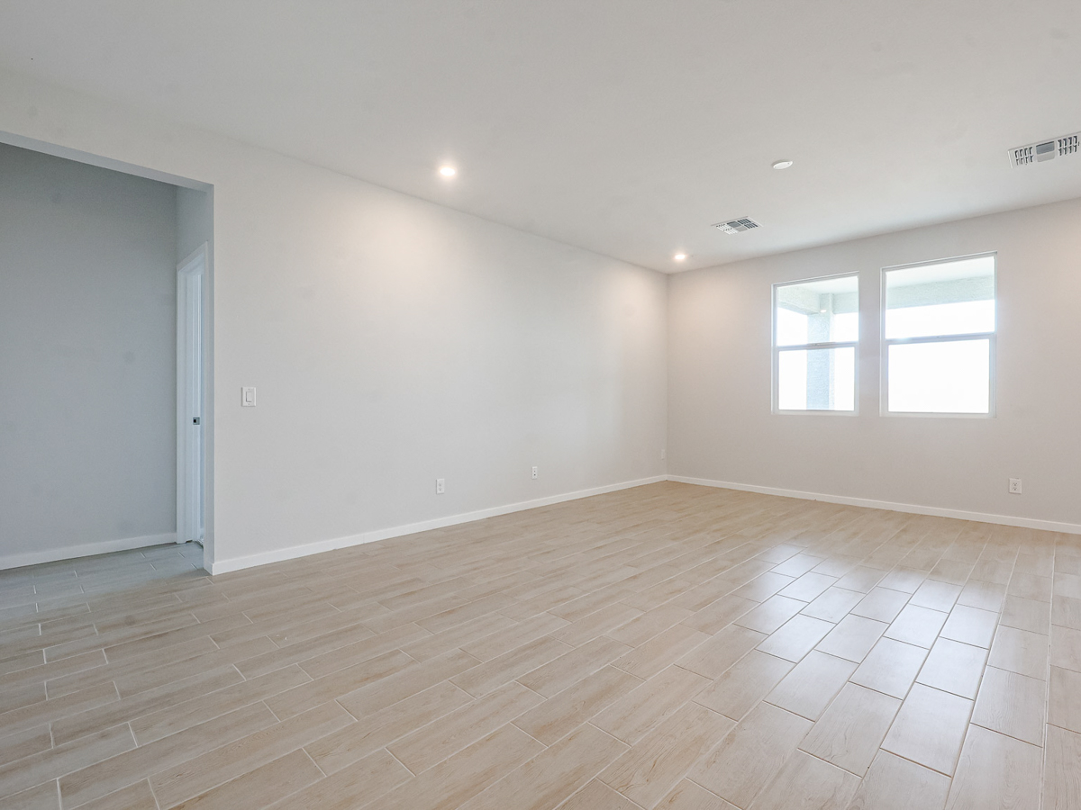 A room with a wood floor and windows.