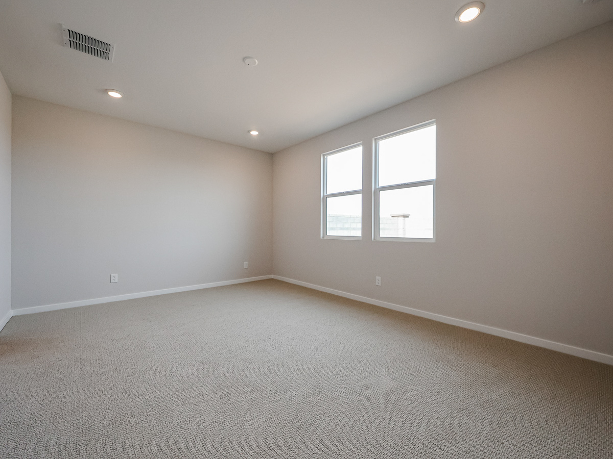 A room with a carpet and a window.