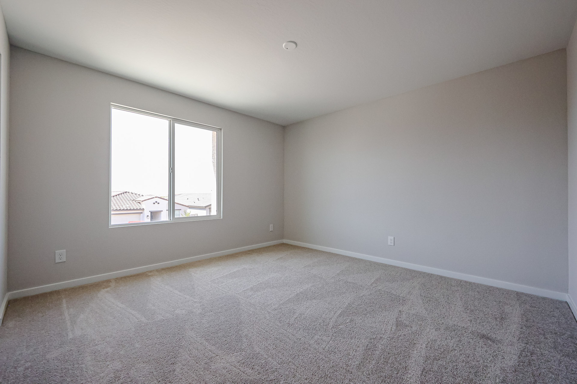 A room with a window and carpet.