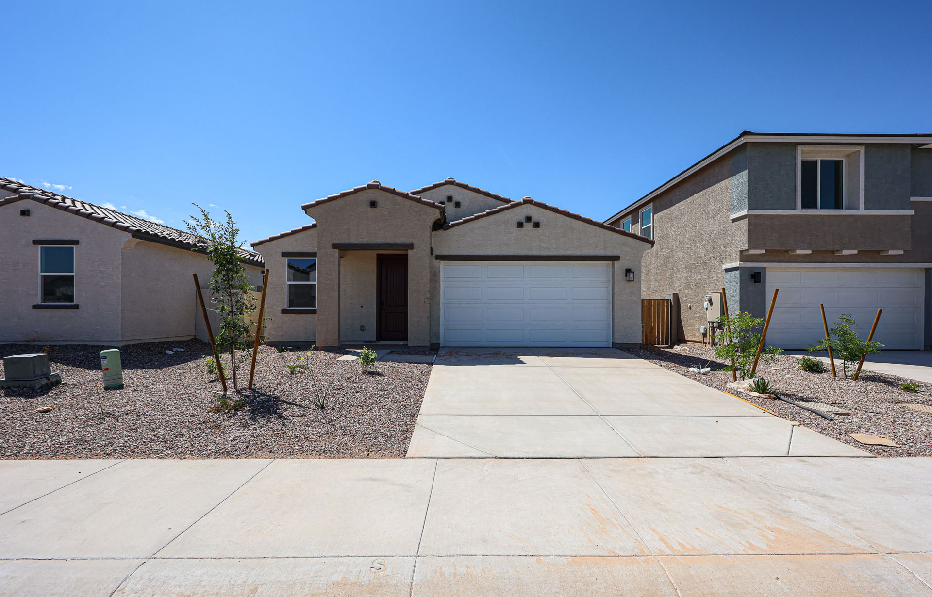A driveway with a garage and a house in the background.