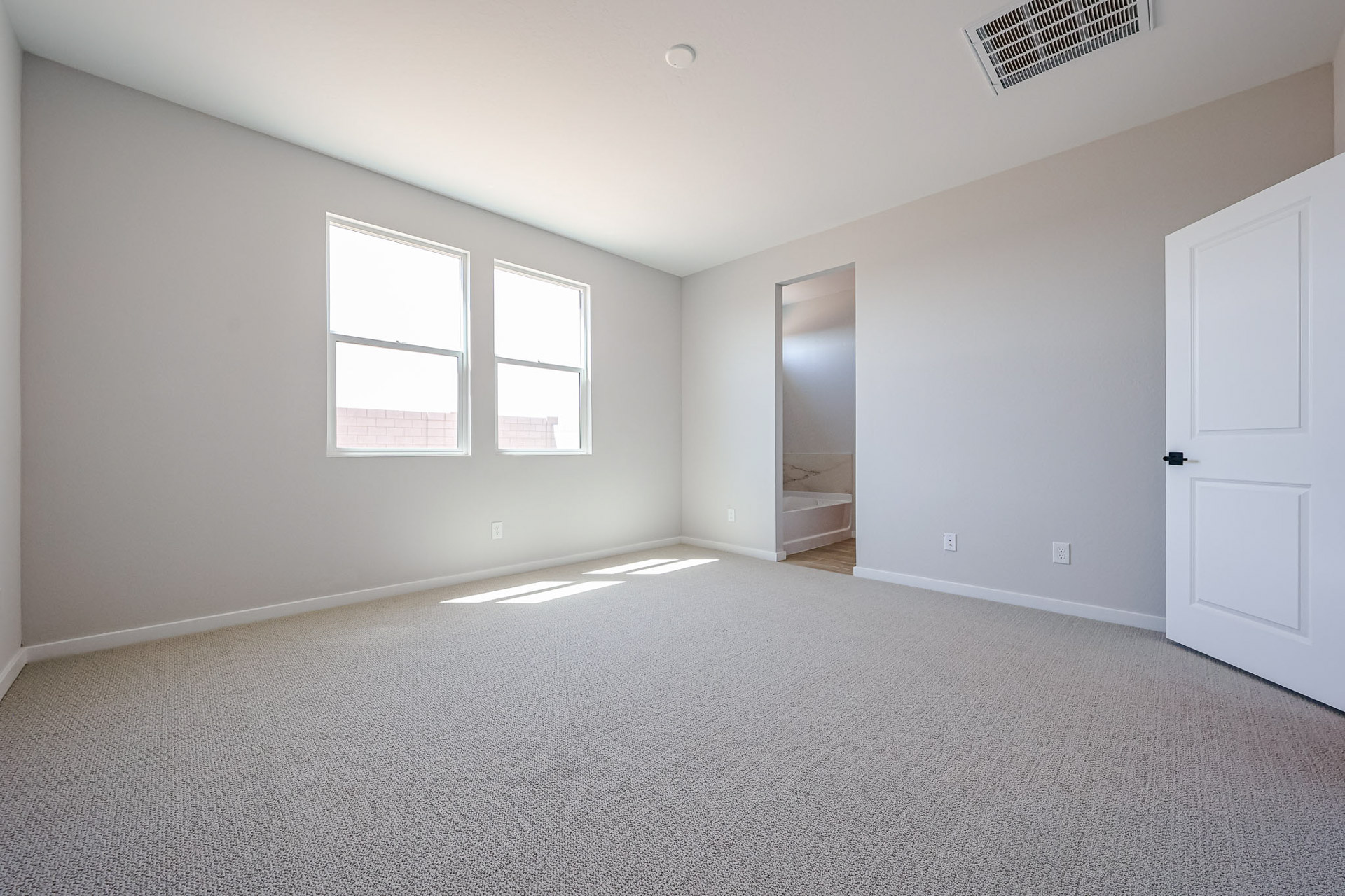 A room with a carpet and a door.
