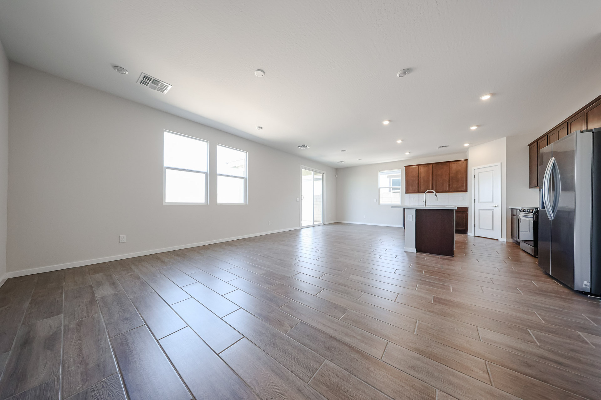 A large empty room with a wood floor and white walls.