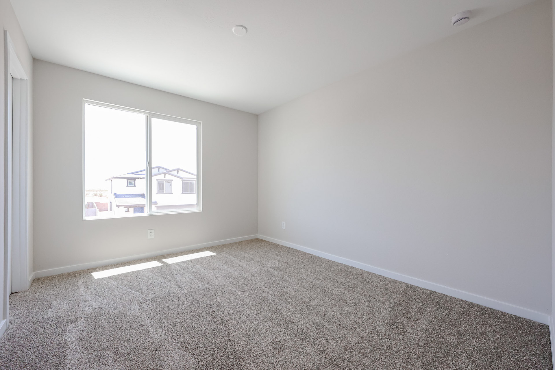 A room with a window and a carpet.