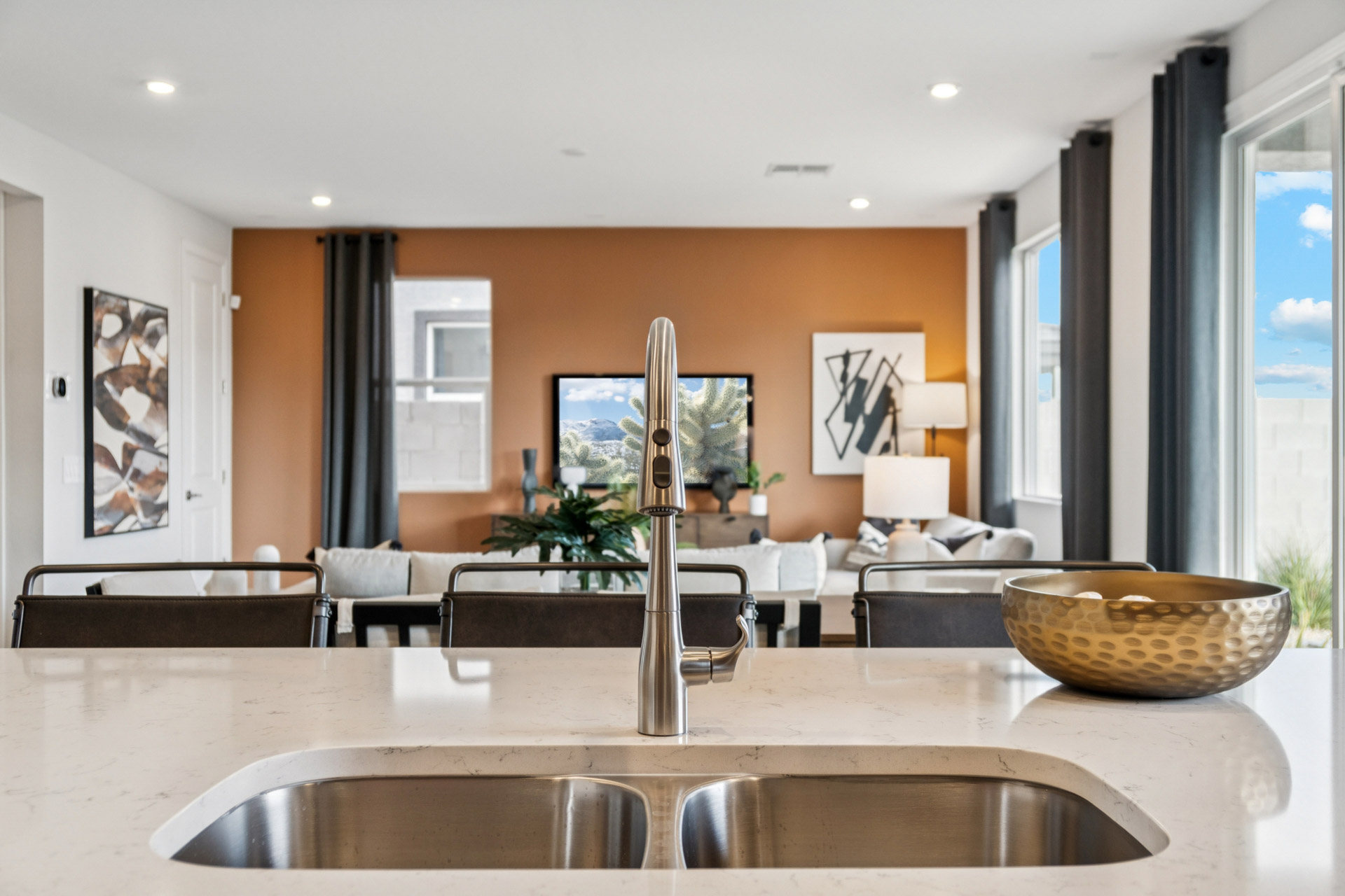 A modern looking kitchen with a large glass table and a large bowl of food.