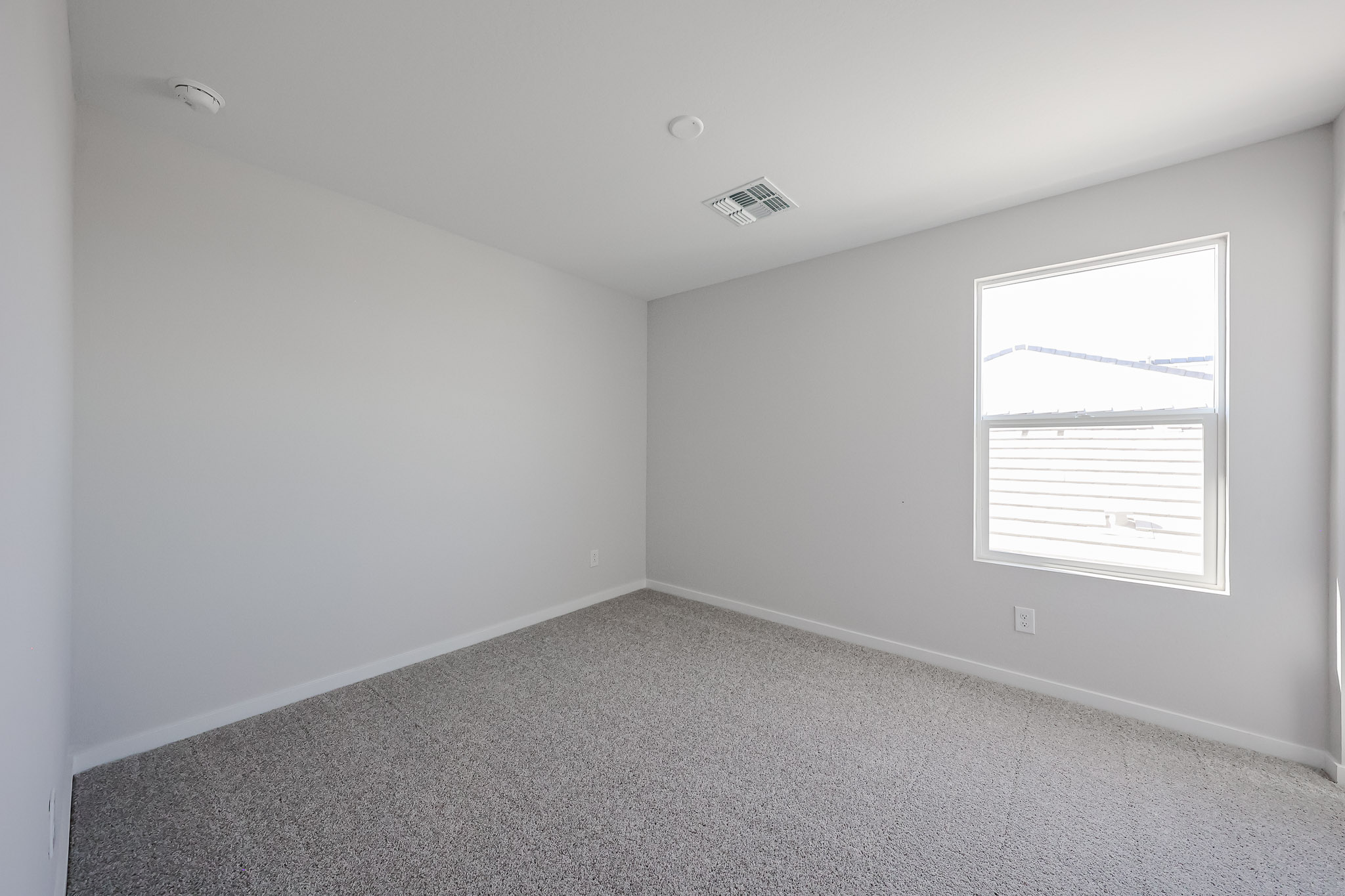 A room with a window and carpet.