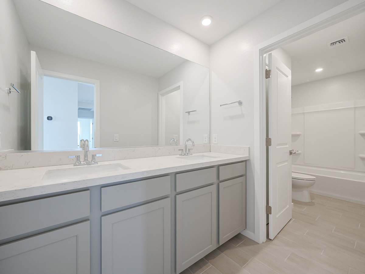A bathroom with white cabinets.
