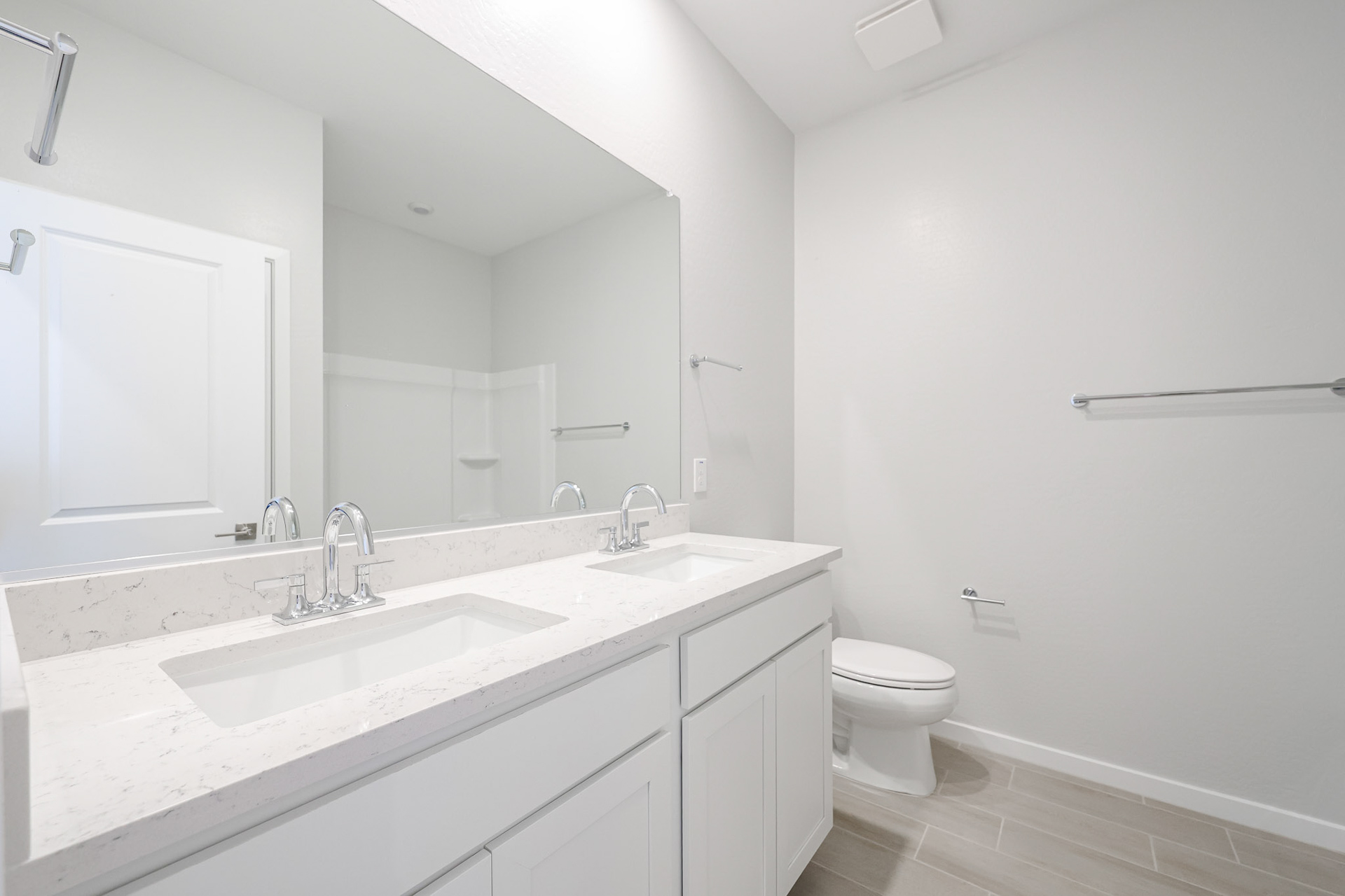 A bathroom with a sink toilet and mirror.