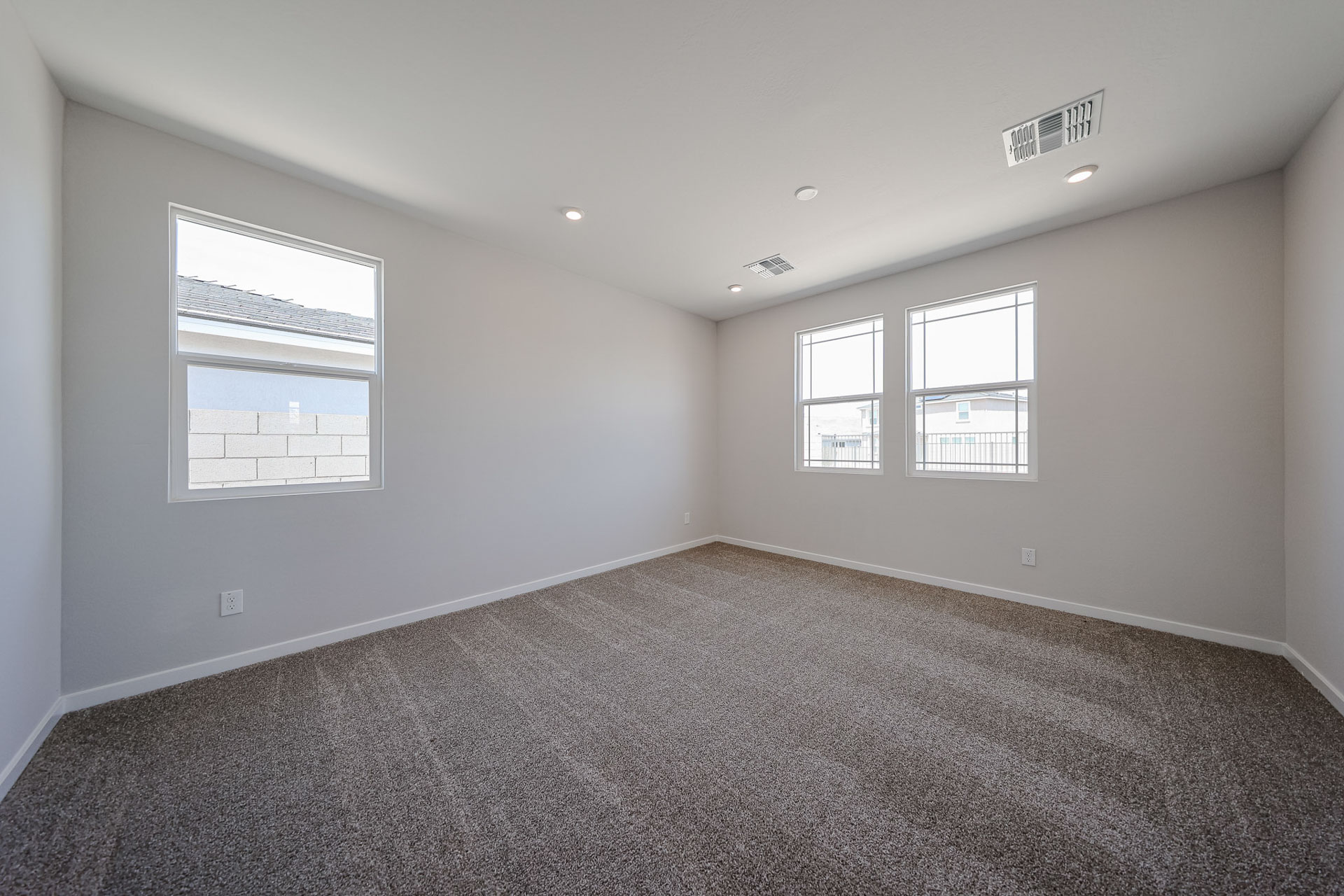A room with a carpet and windows.