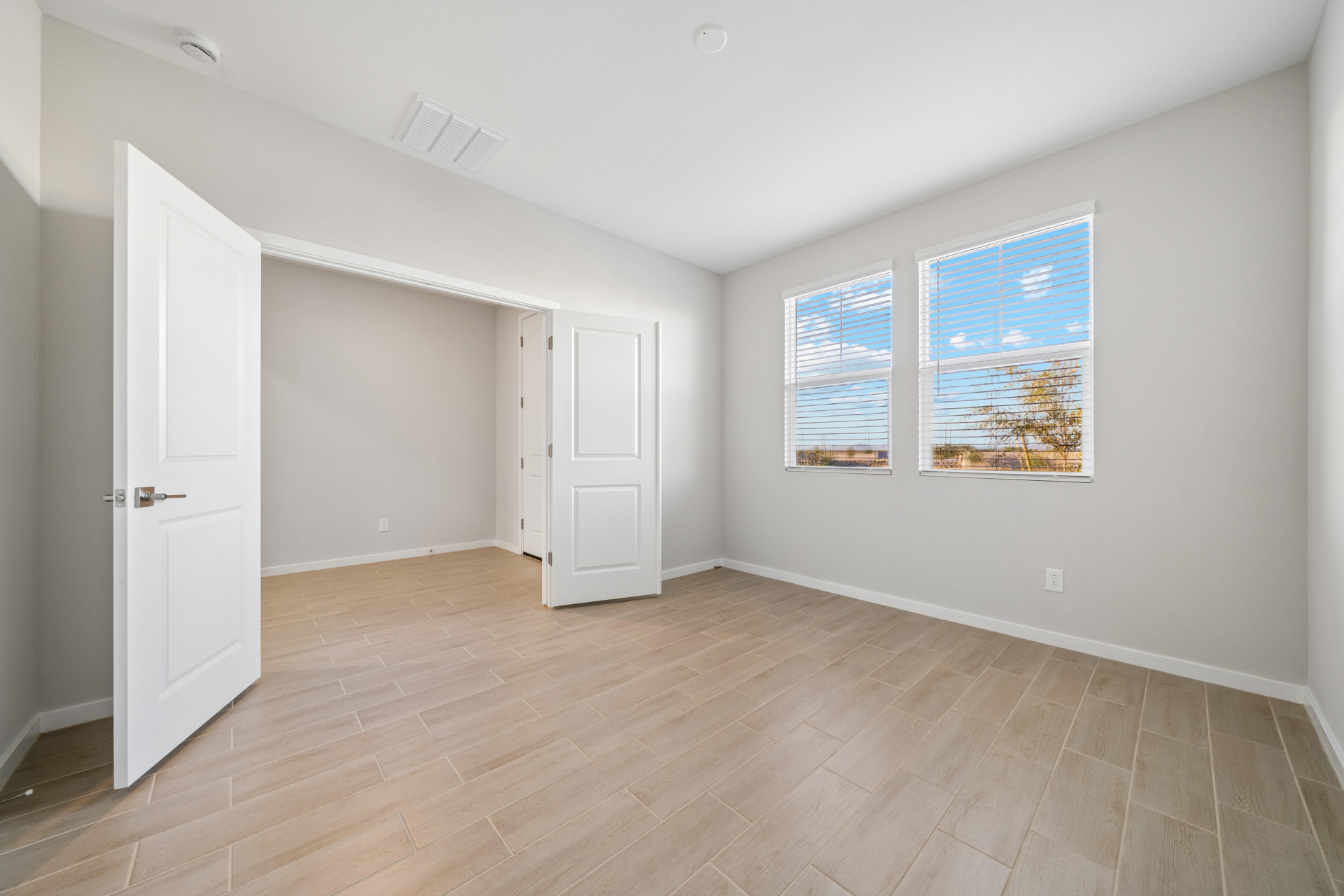 A room with a wood floor and white doors.