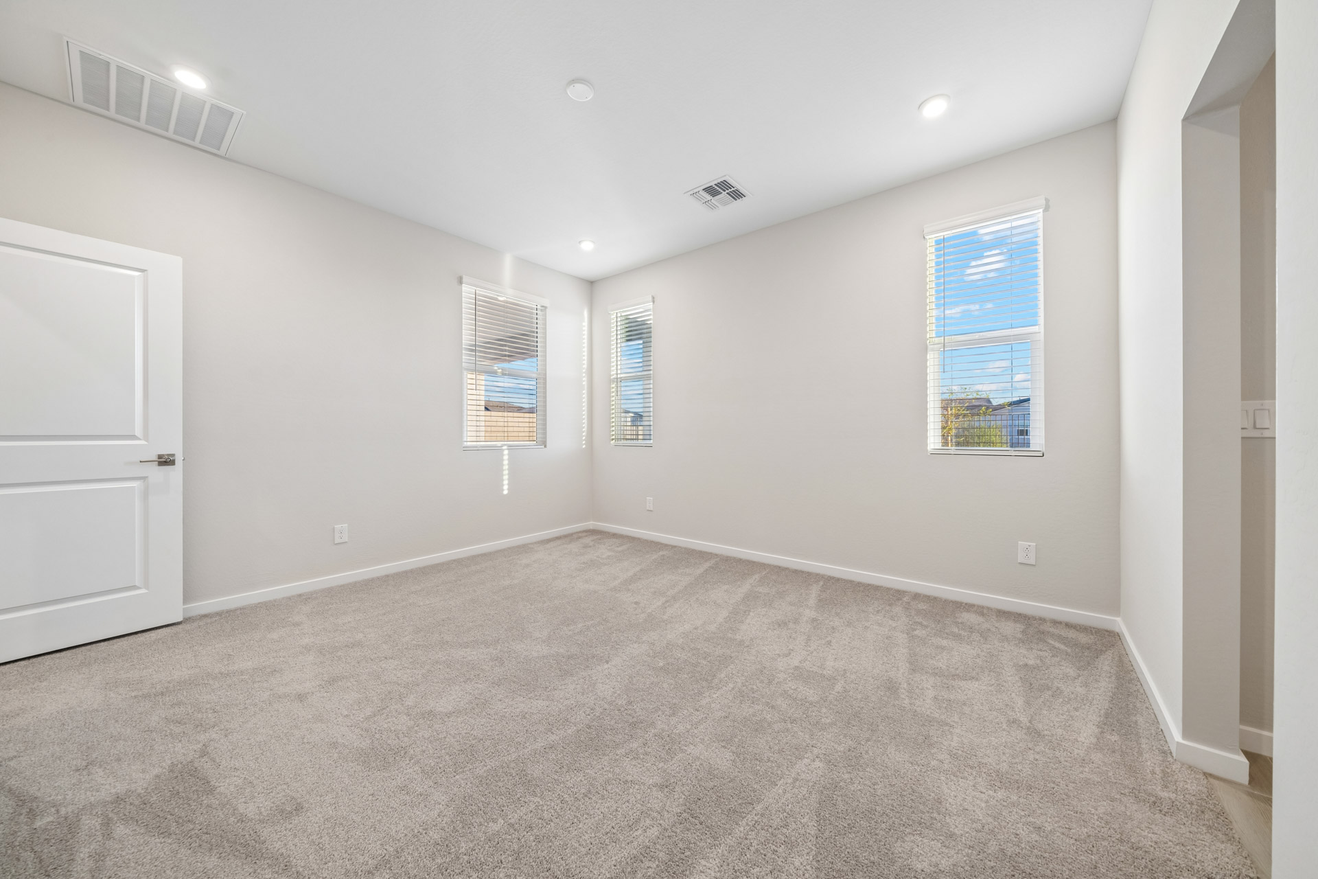 A room with a carpet and a door.