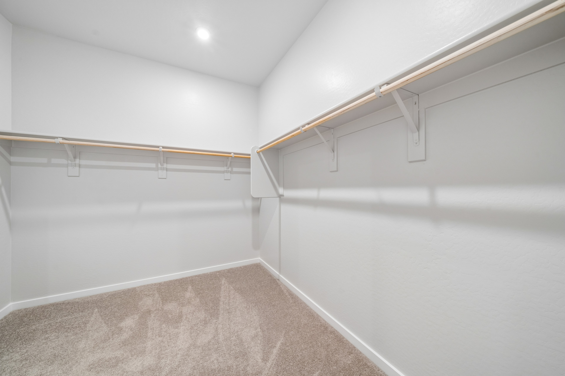 A white hallway with a metal railing.