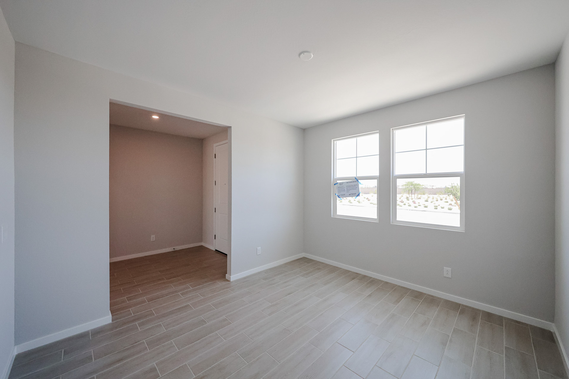 A room with a wood floor and a wood floor with a door.