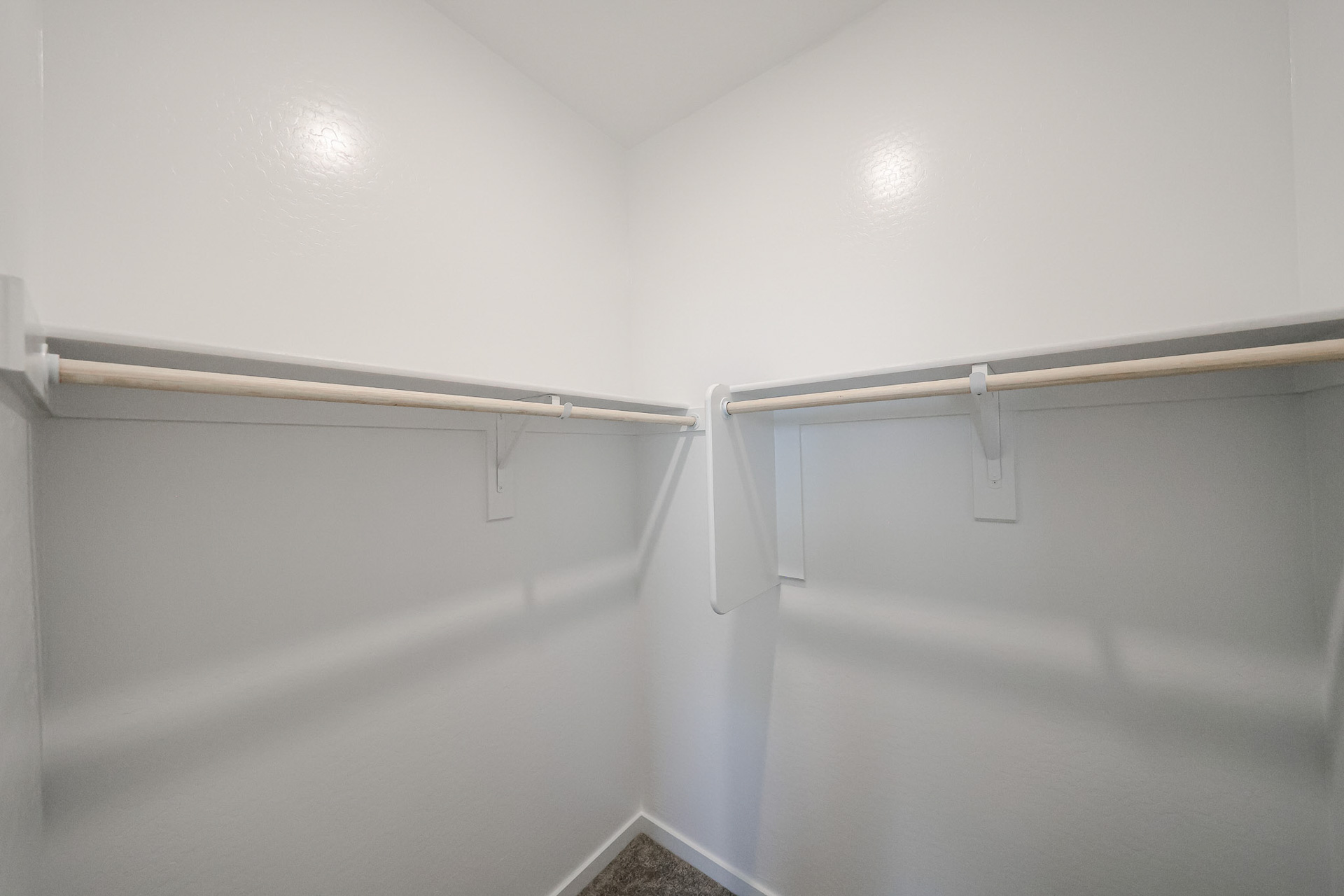 A white wall with a metal bar.