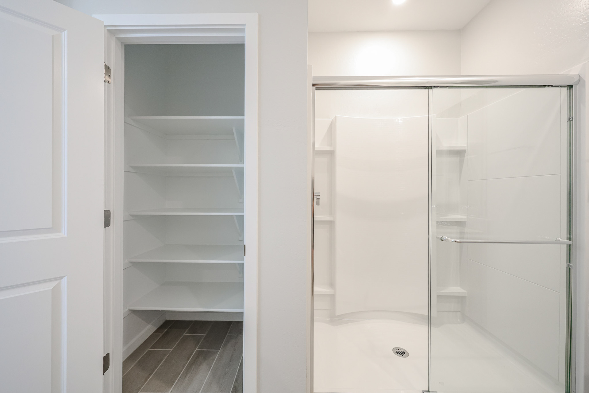 A white closet with glass doors.