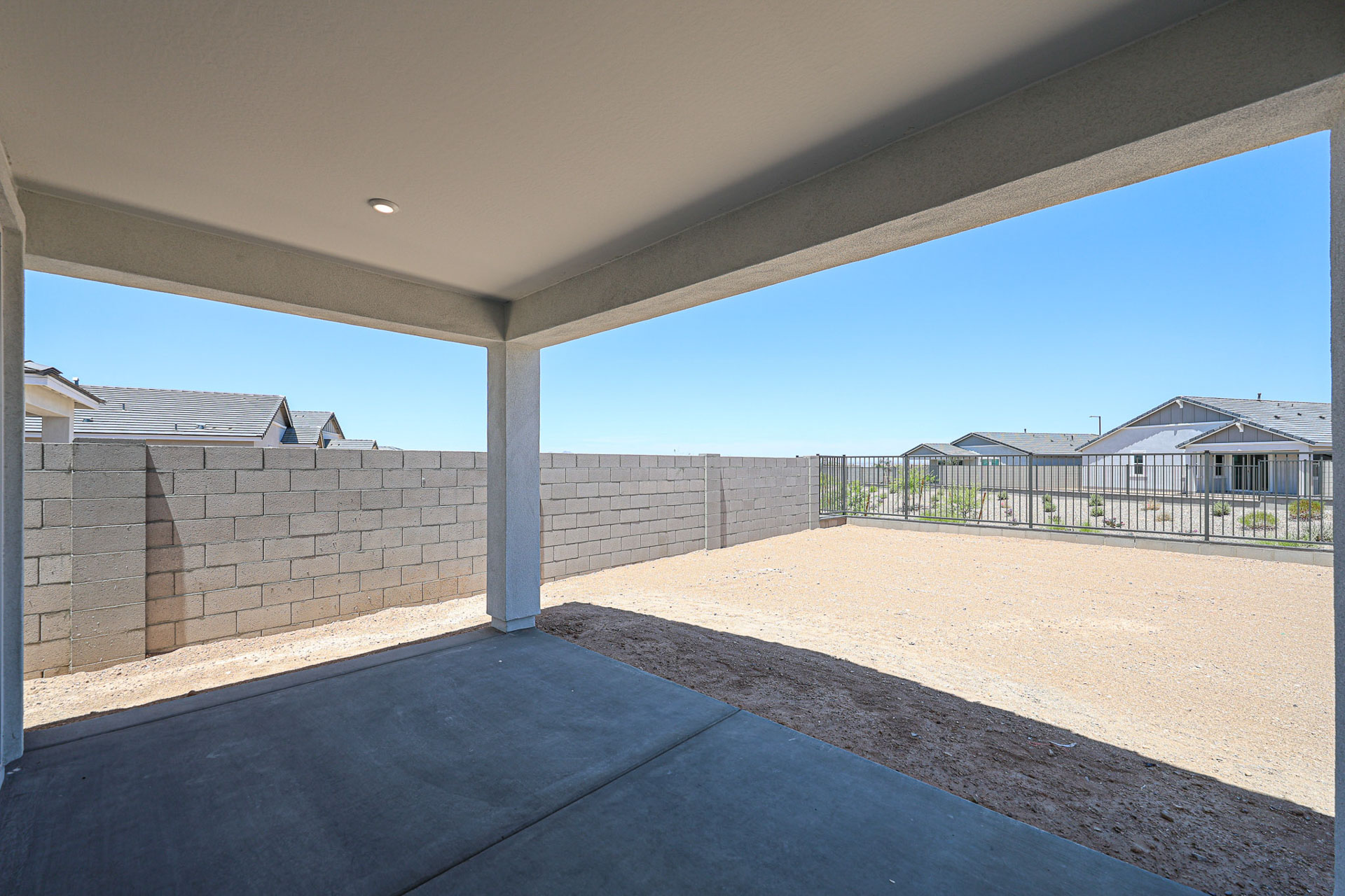 A wall with a railing and a building in the background.
