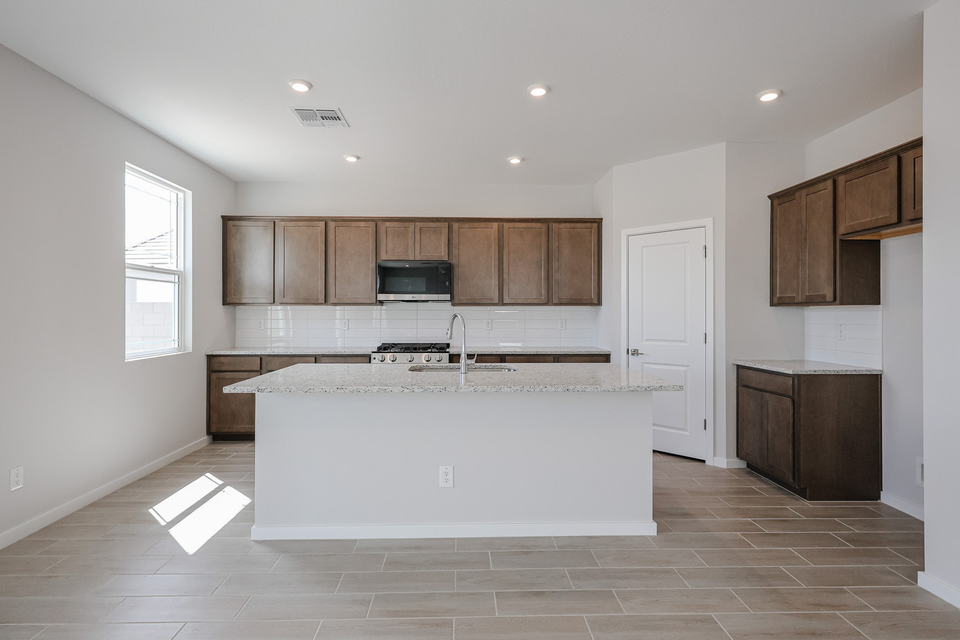 A kitchen with a marble counter top.