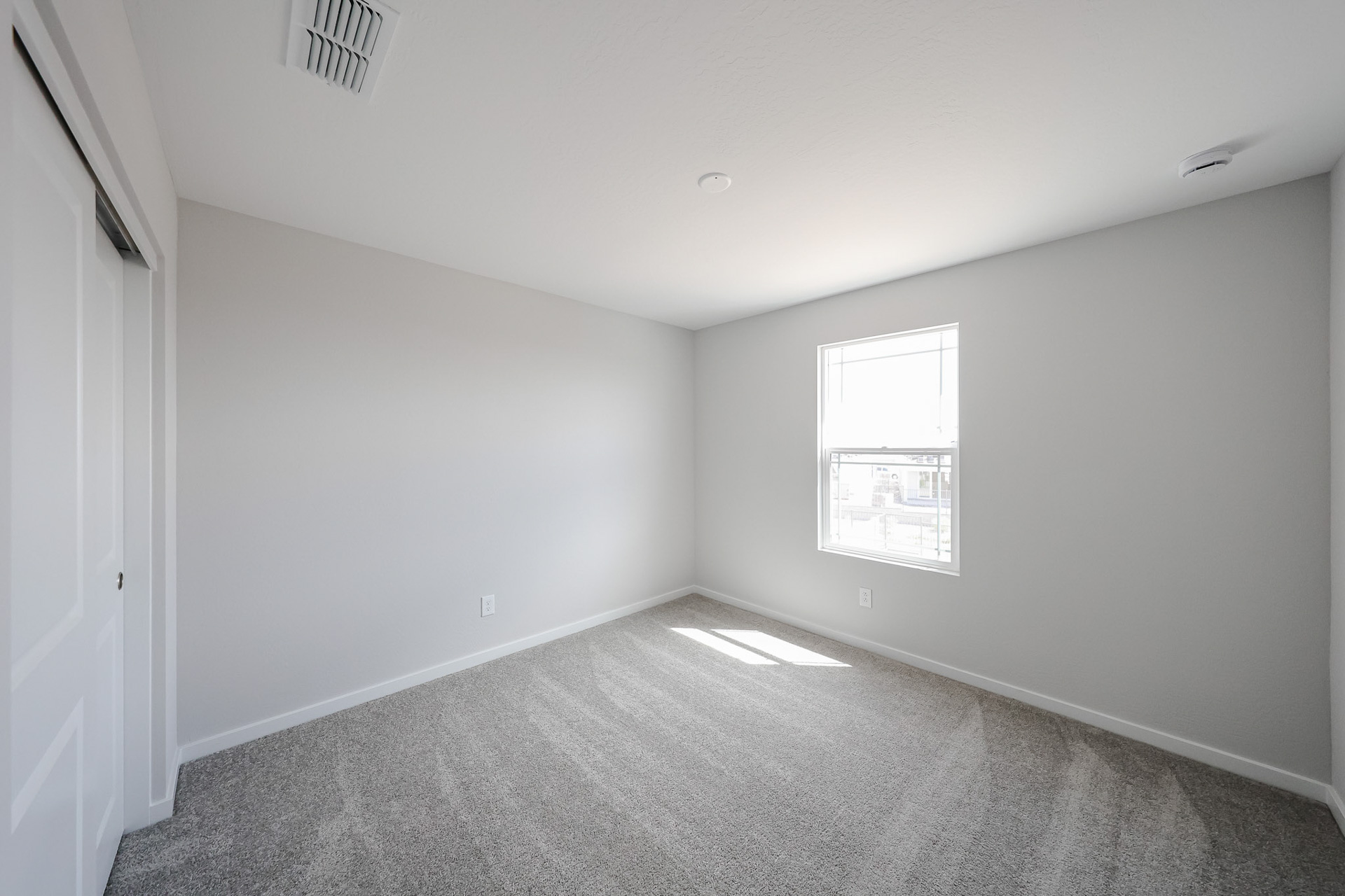 A room with a carpet and windows.