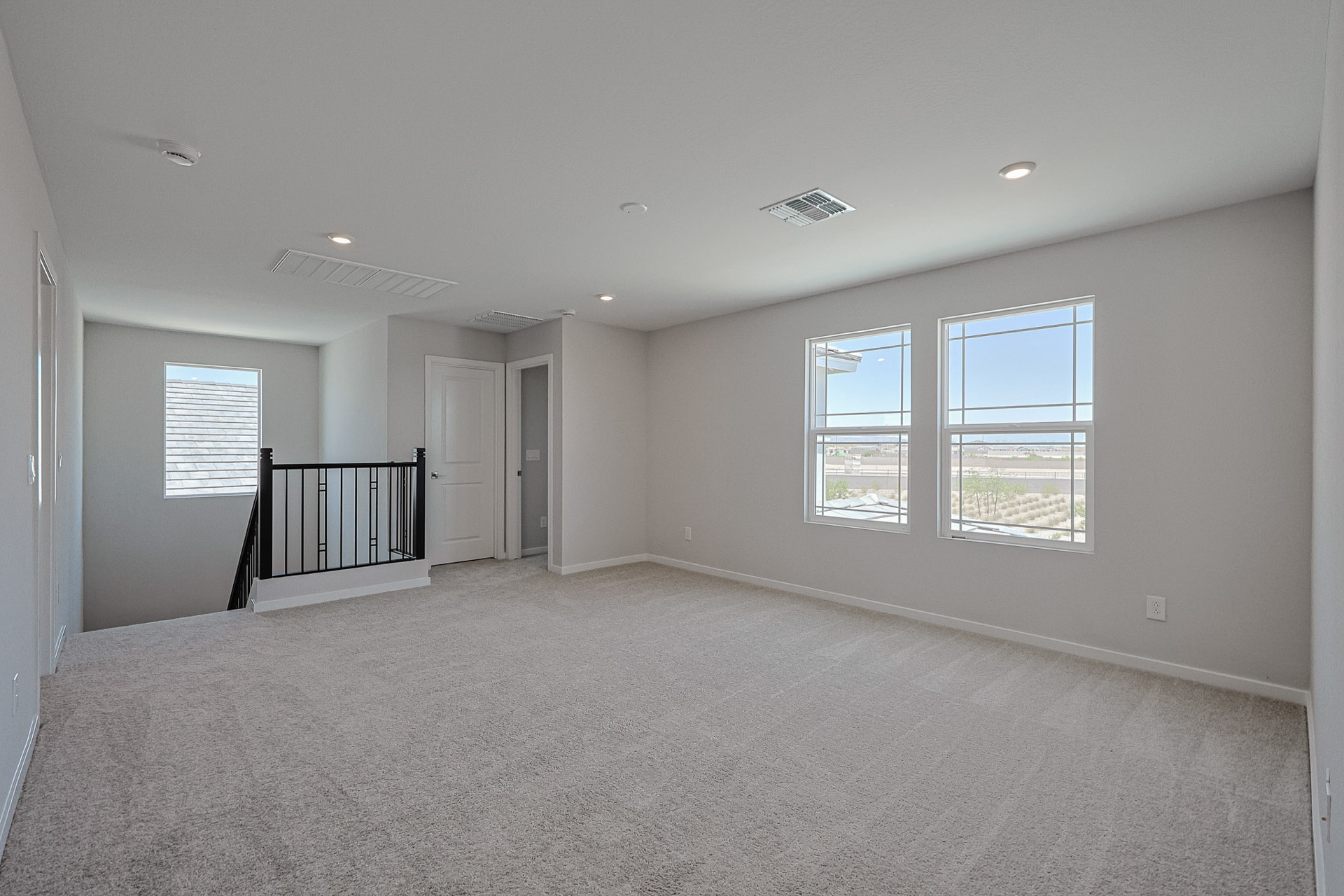 A room with a carpet and windows.