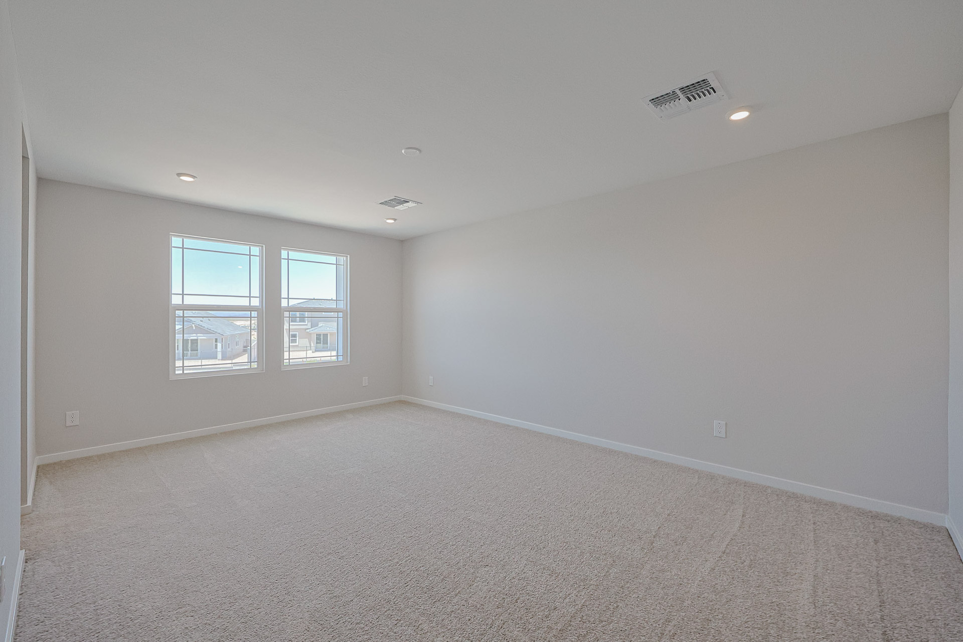 A room with a carpet and windows.