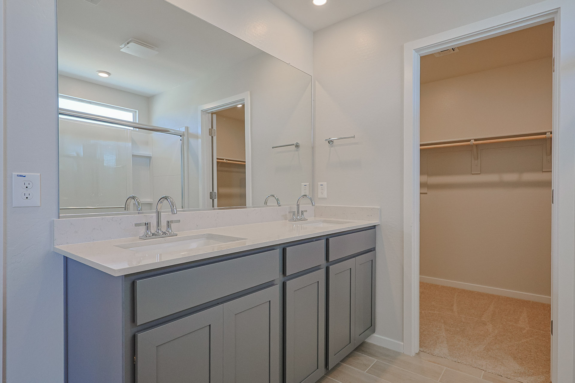 A bathroom with a sink and a shower unit.