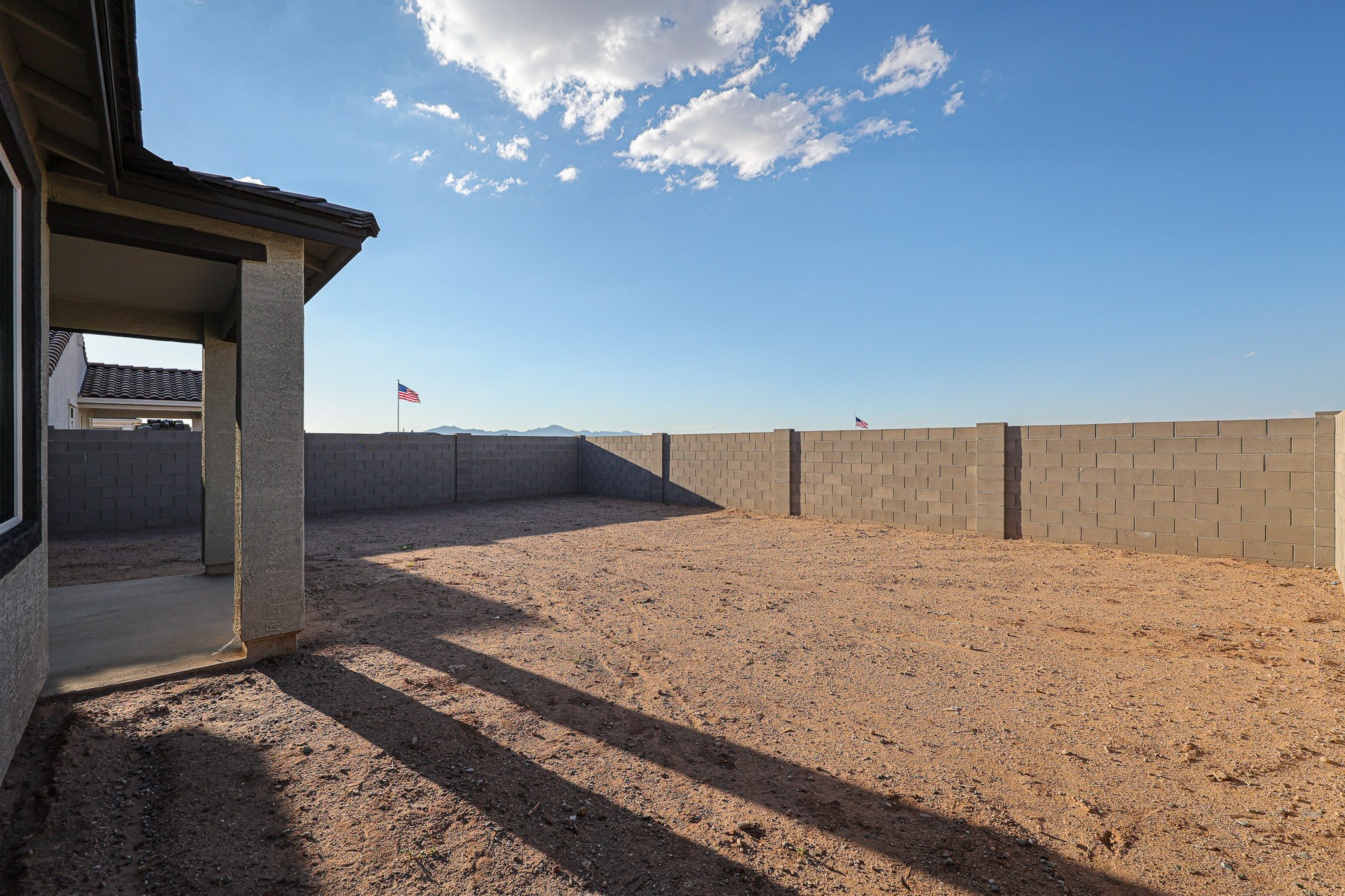 A dirt road with a building on the side.