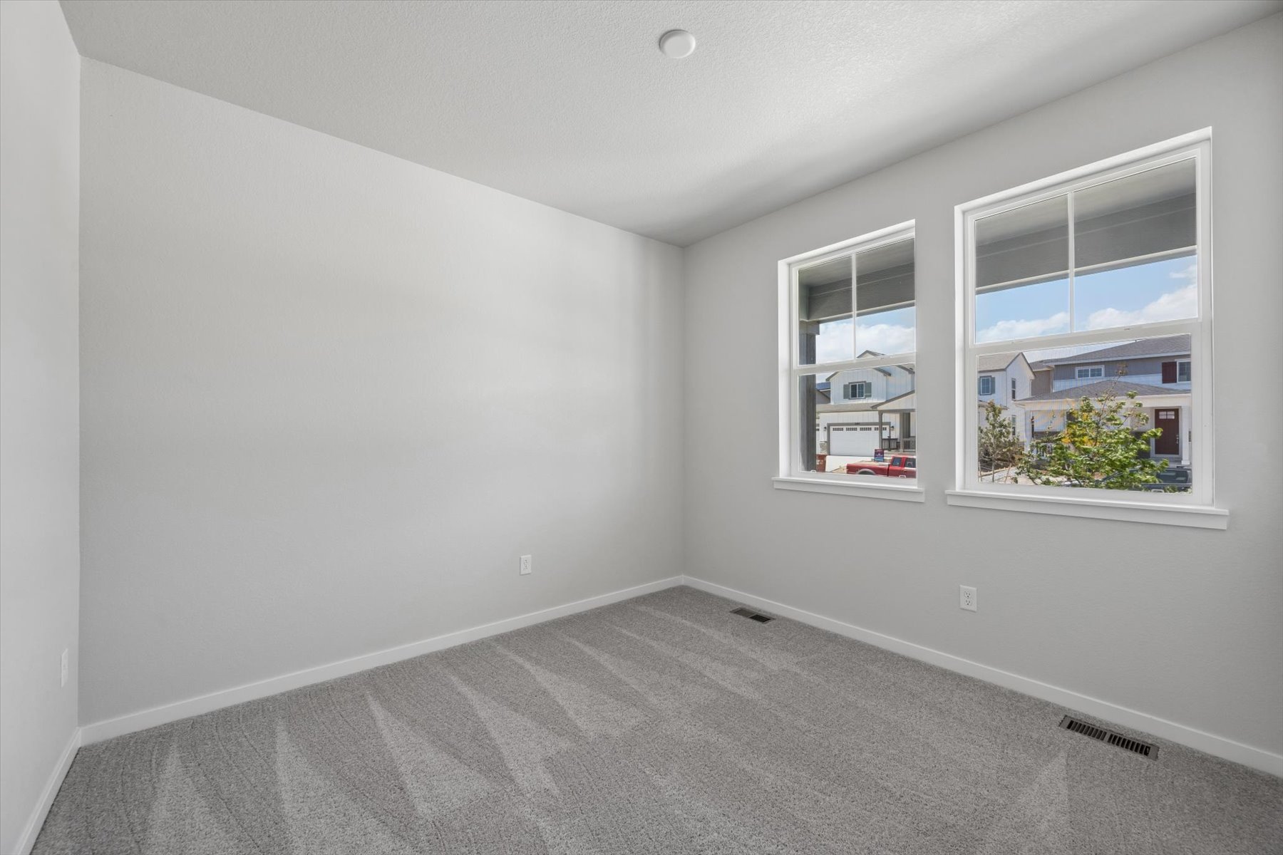 A room with a carpet and windows.