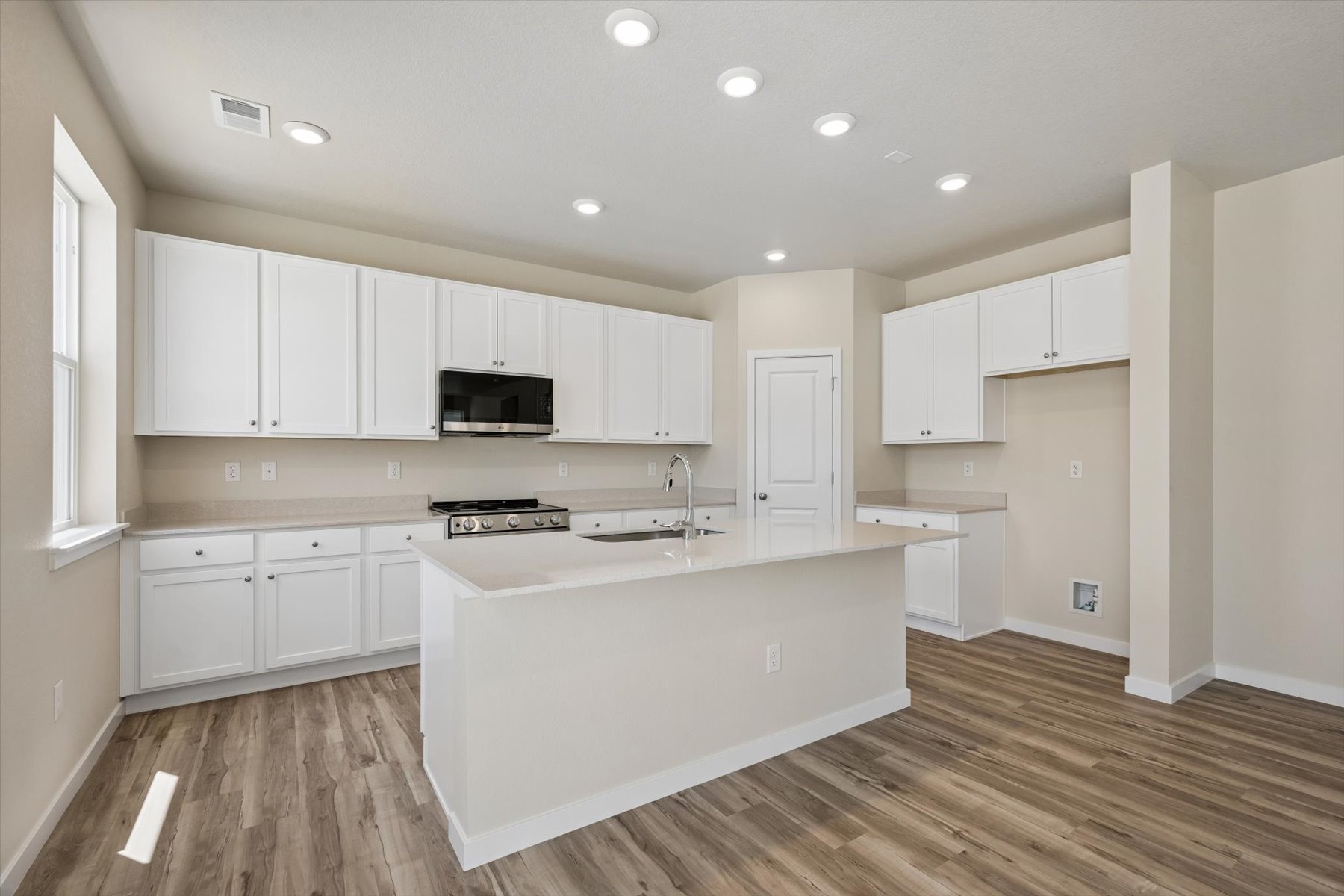 A kitchen with white cabinets.