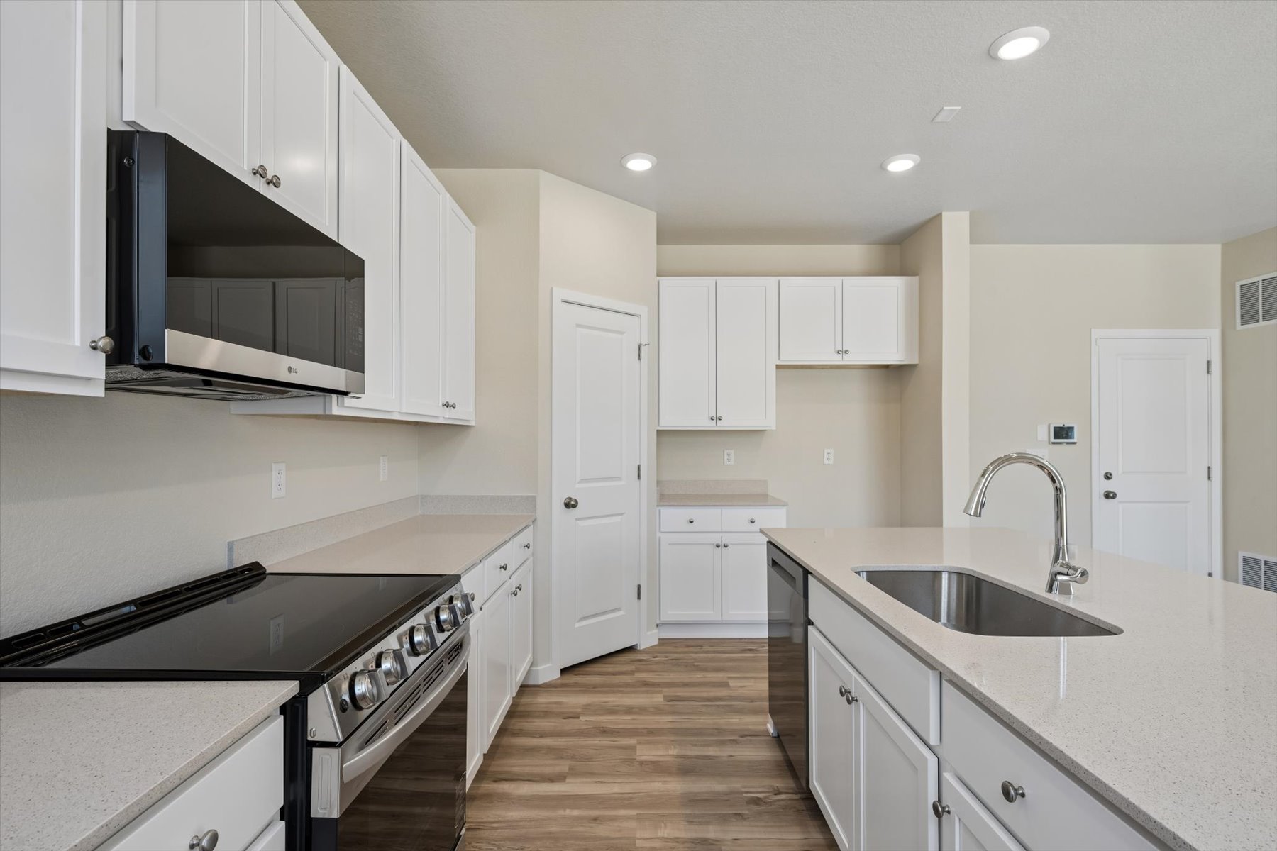 A kitchen with white cabinets.