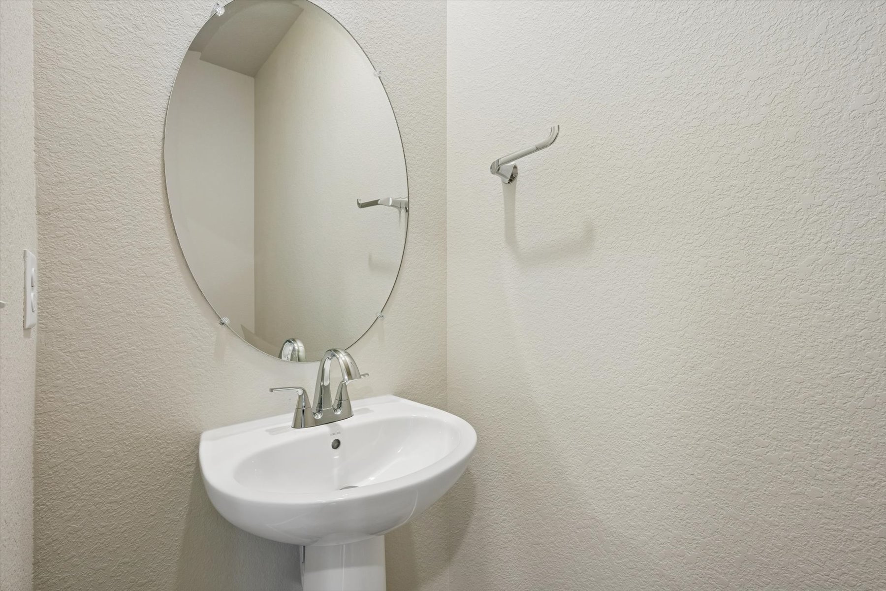 A bathroom with a round mirror.