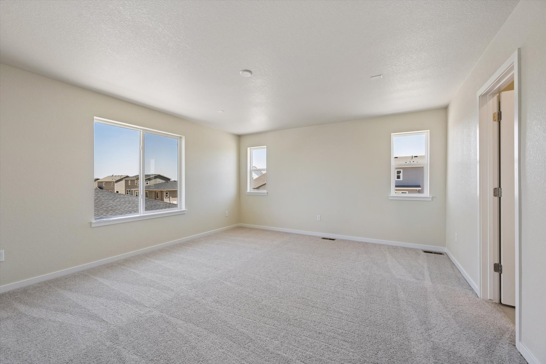 A room with a carpet and windows.
