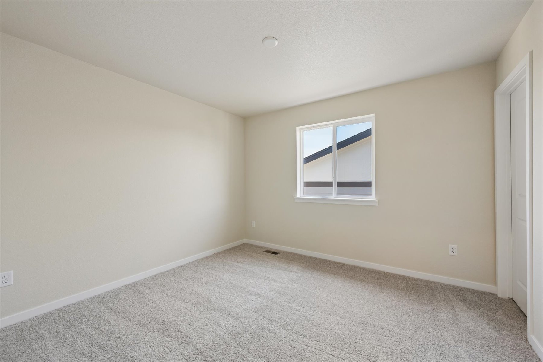 A room with a window and a carpet.