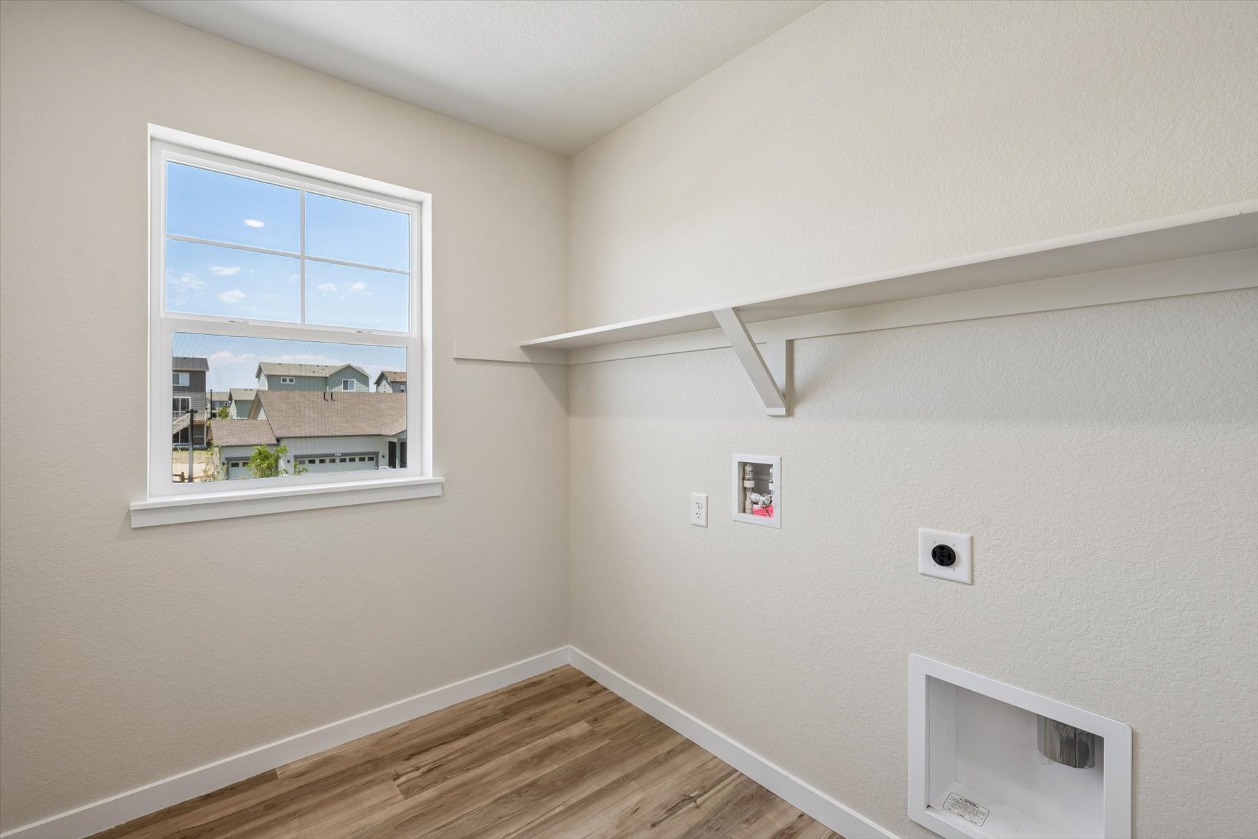 A room with a window and a wood floor.
