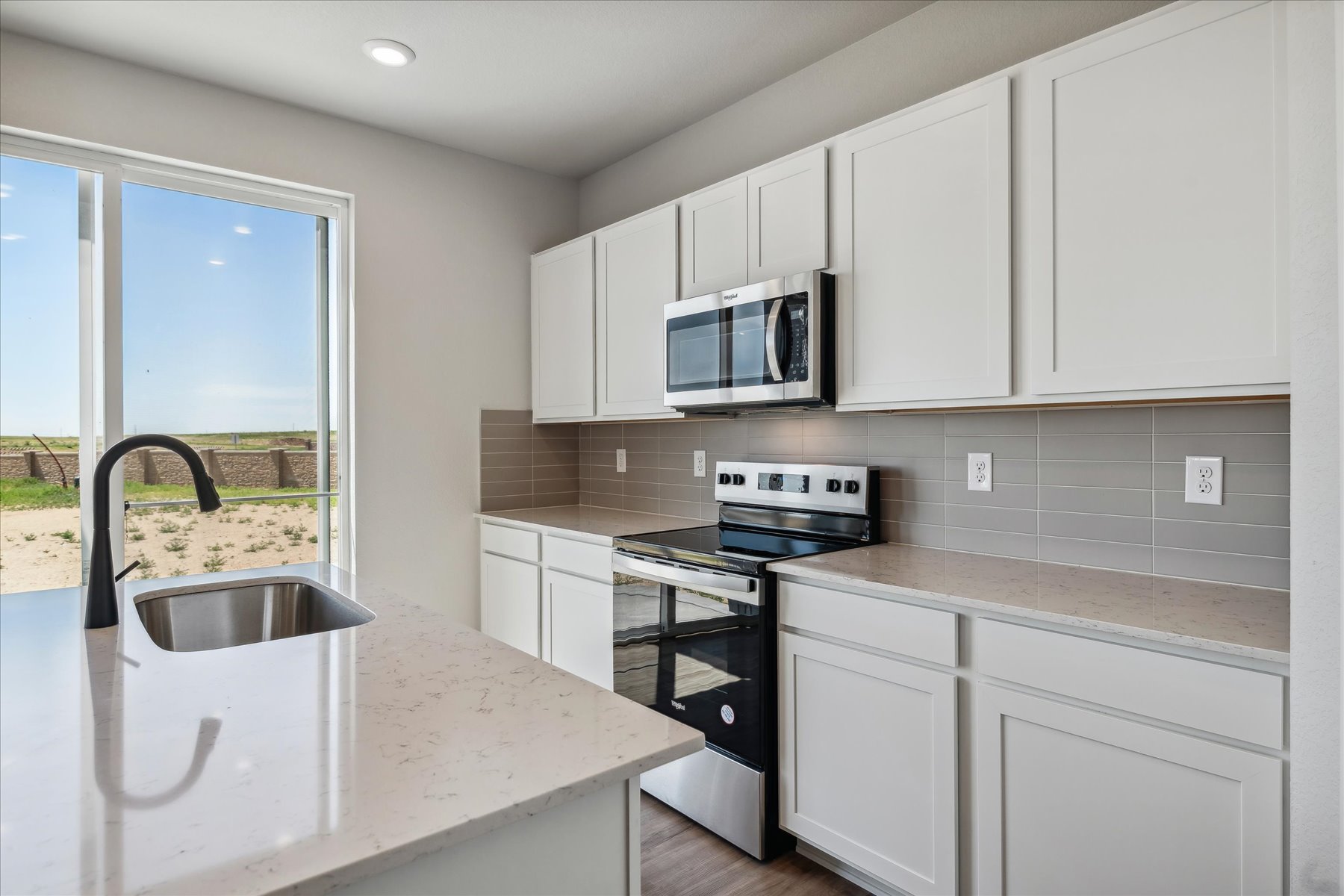 A kitchen with white cabinets.