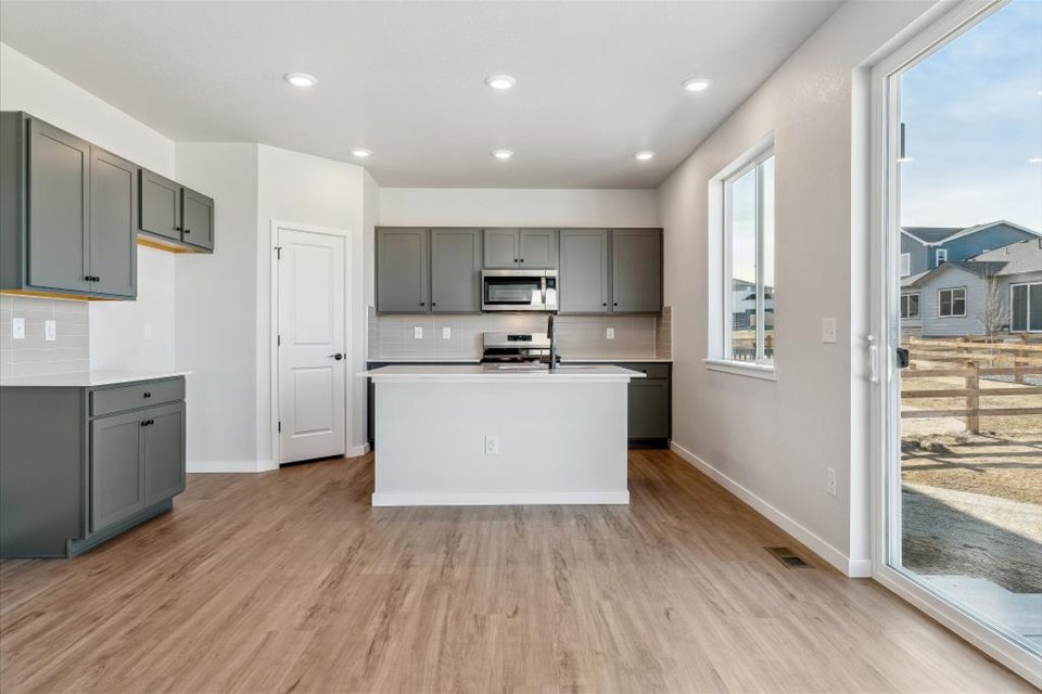 A kitchen with white cabinets.
