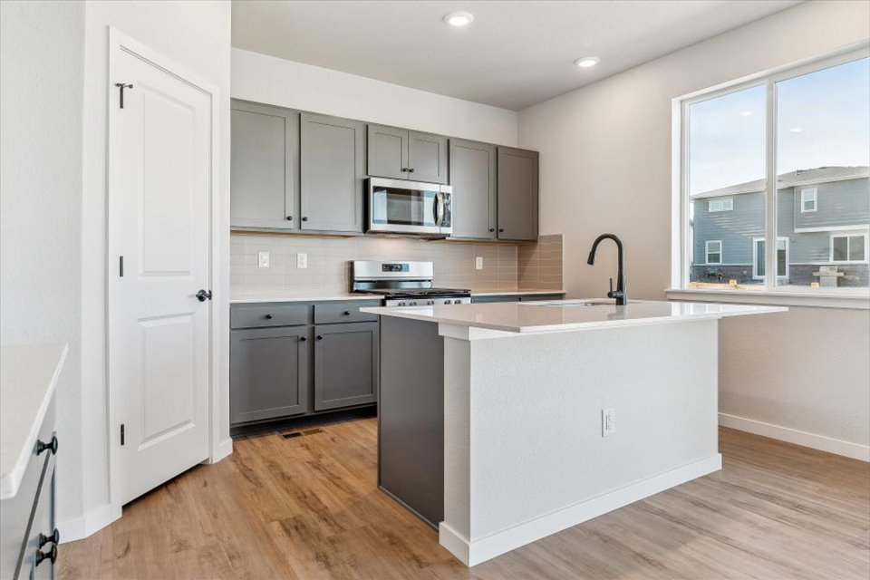A kitchen with white cabinets.