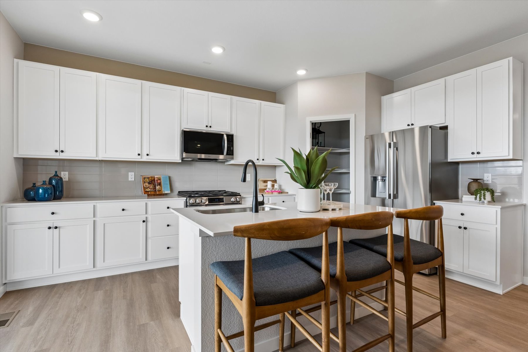A kitchen with white cabinets.