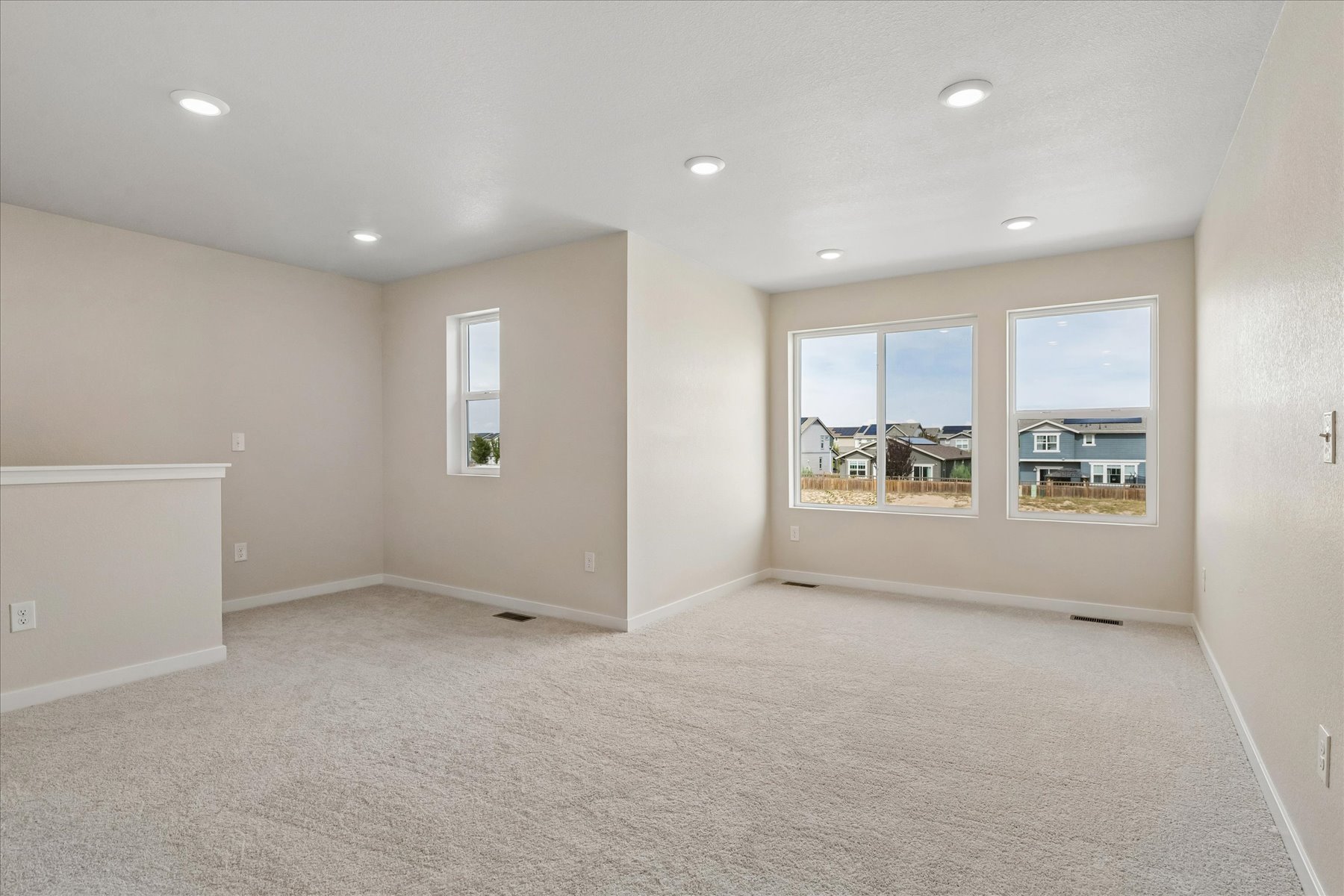 A room with a carpet and windows.