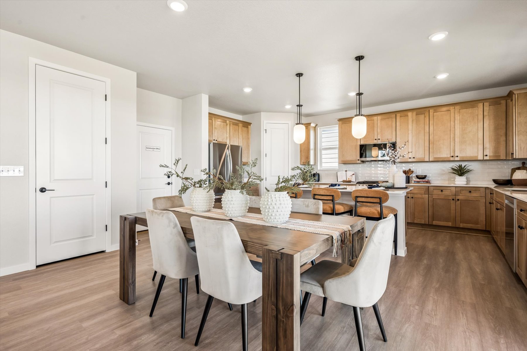 A kitchen with a dining table and chairs.