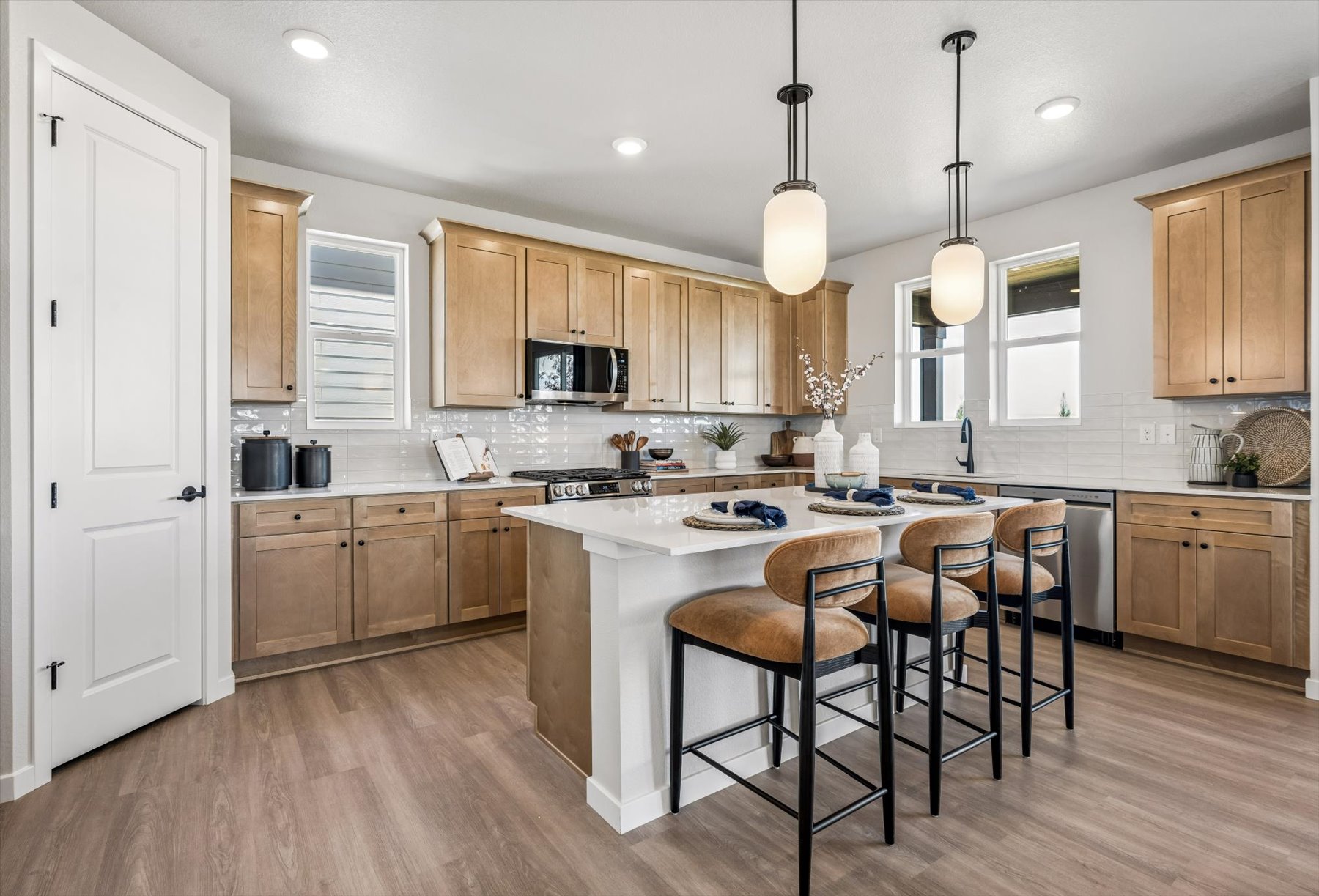 A kitchen with a table and chairs.