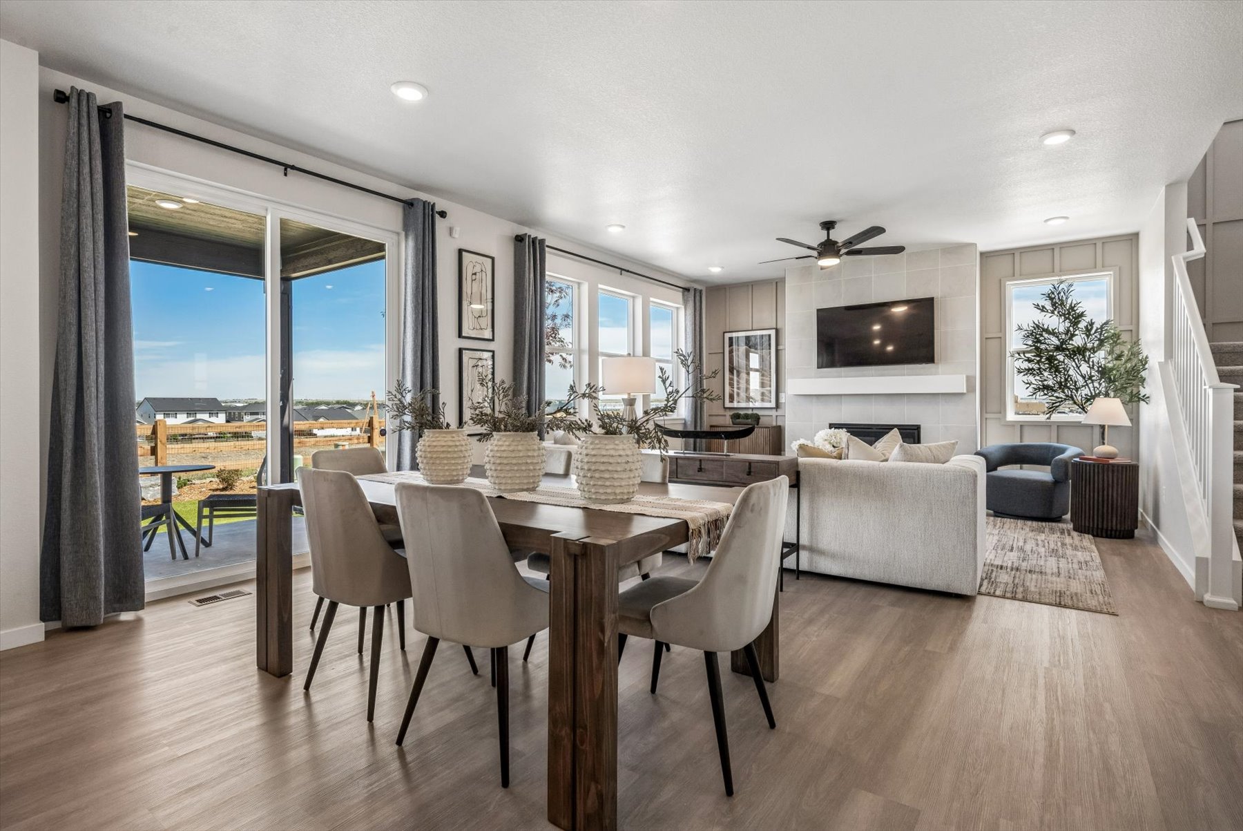 A large living room with a large dining table and large windows.