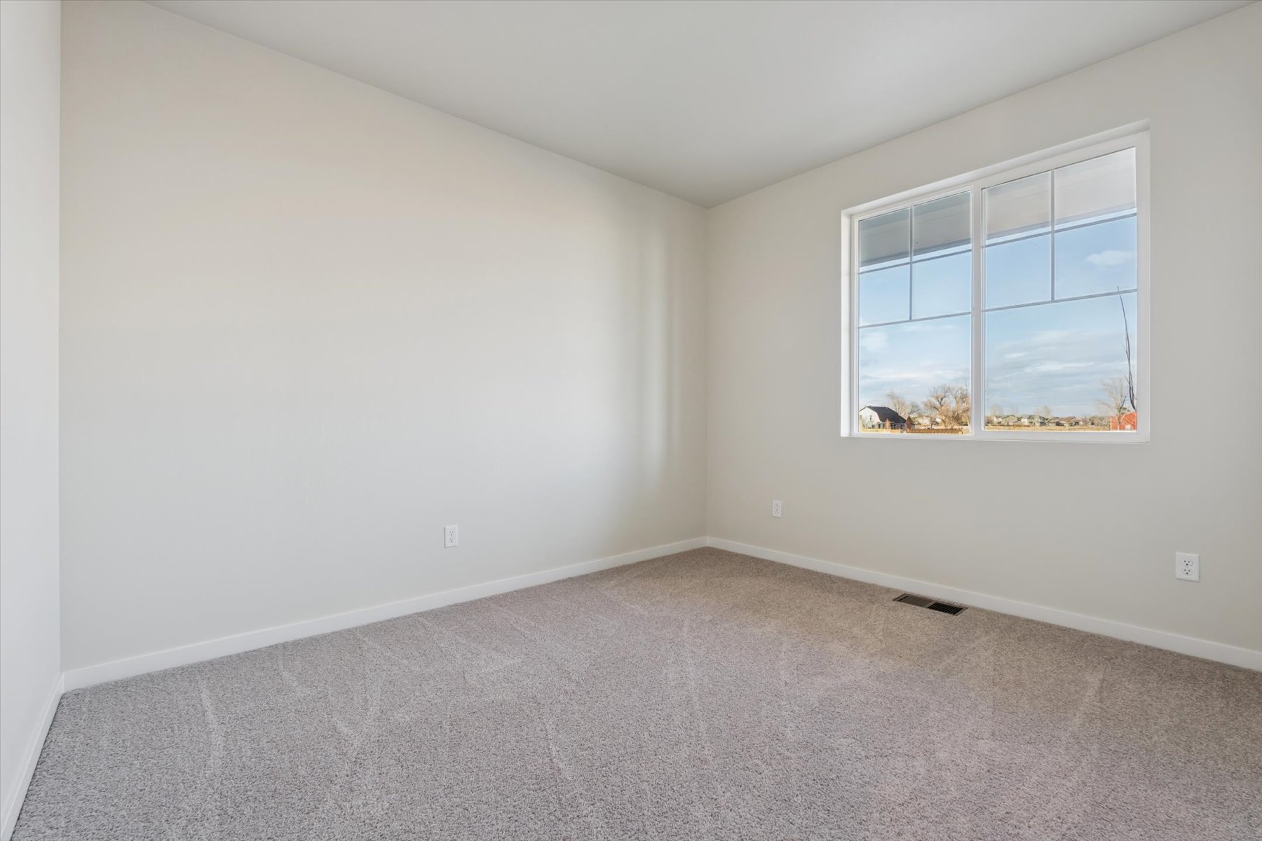 A room with a window and a carpet.