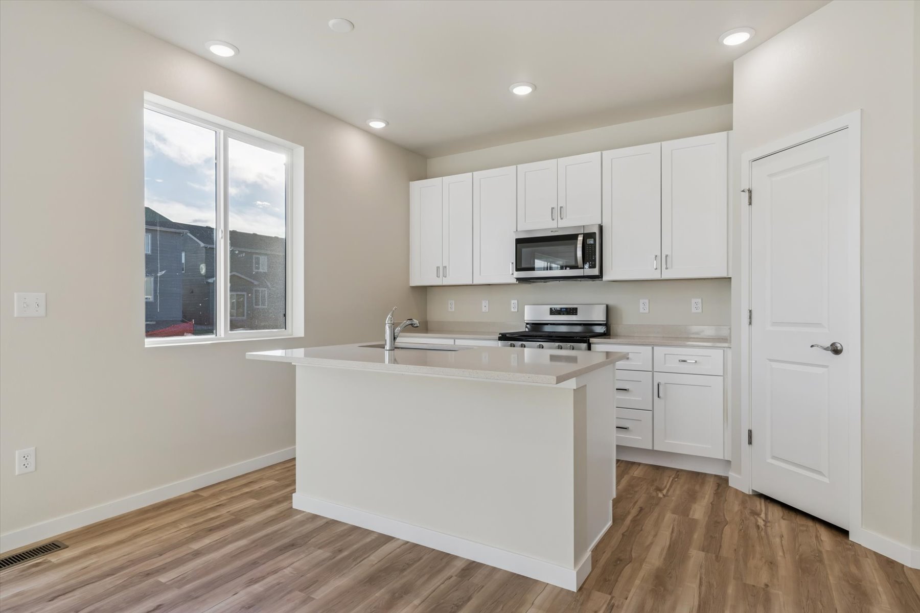 A kitchen with white cabinets.