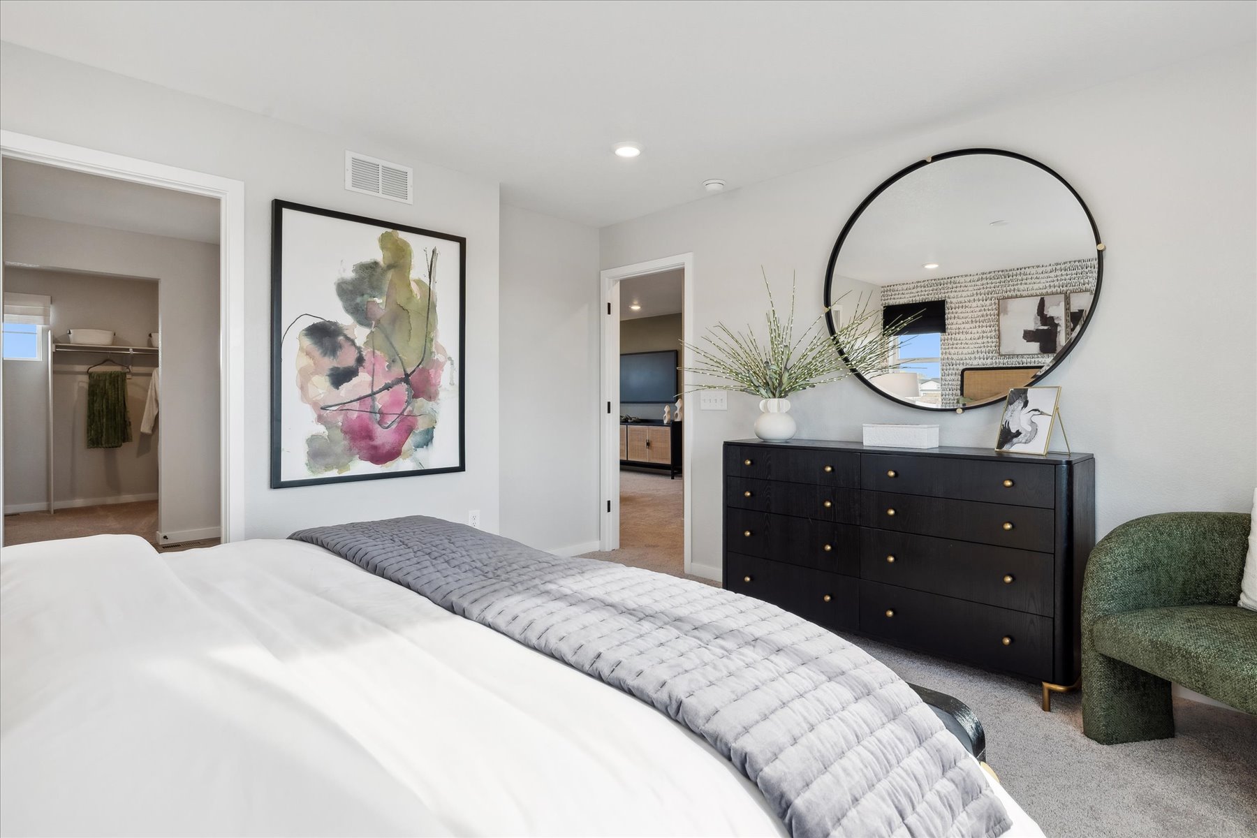 A bedroom with a large mirror.